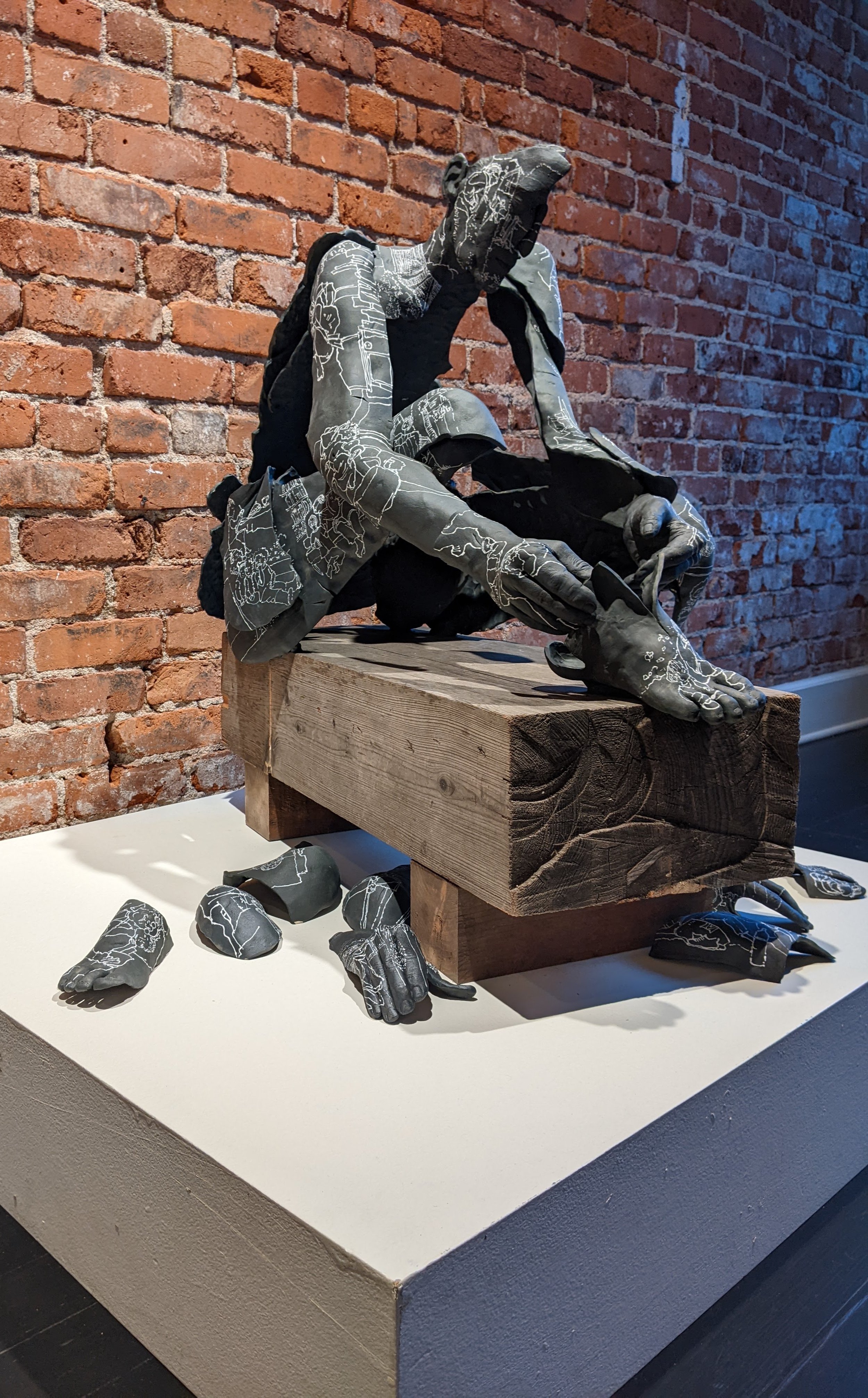 Lost & Found (2024) full ceramic figure with wood bench form
