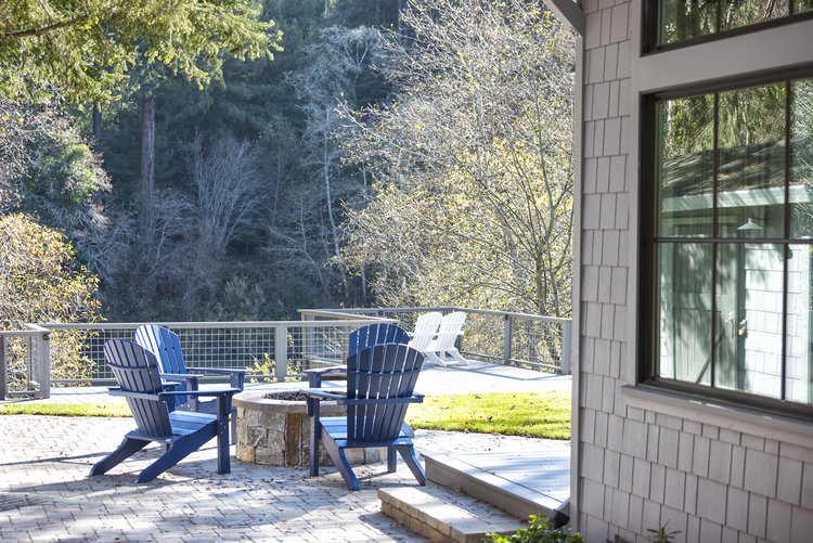  Blue Adirondack chairs around a fire pit. The lawn is visible behind the chairs.  
