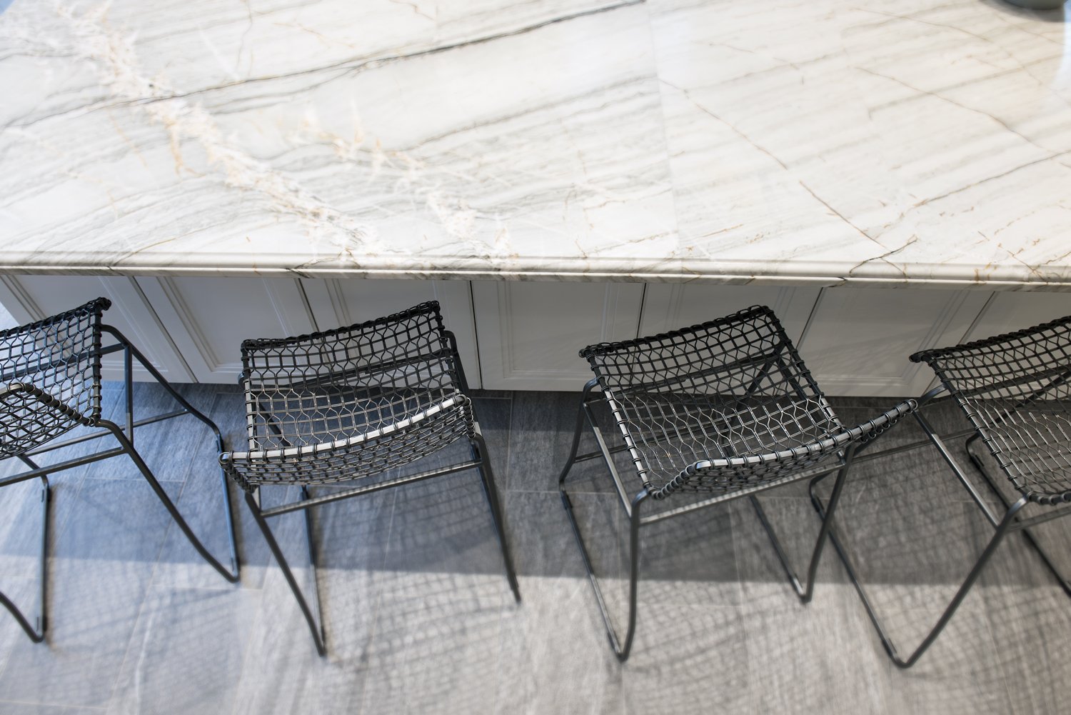  A kitchen island with black bar seating.  