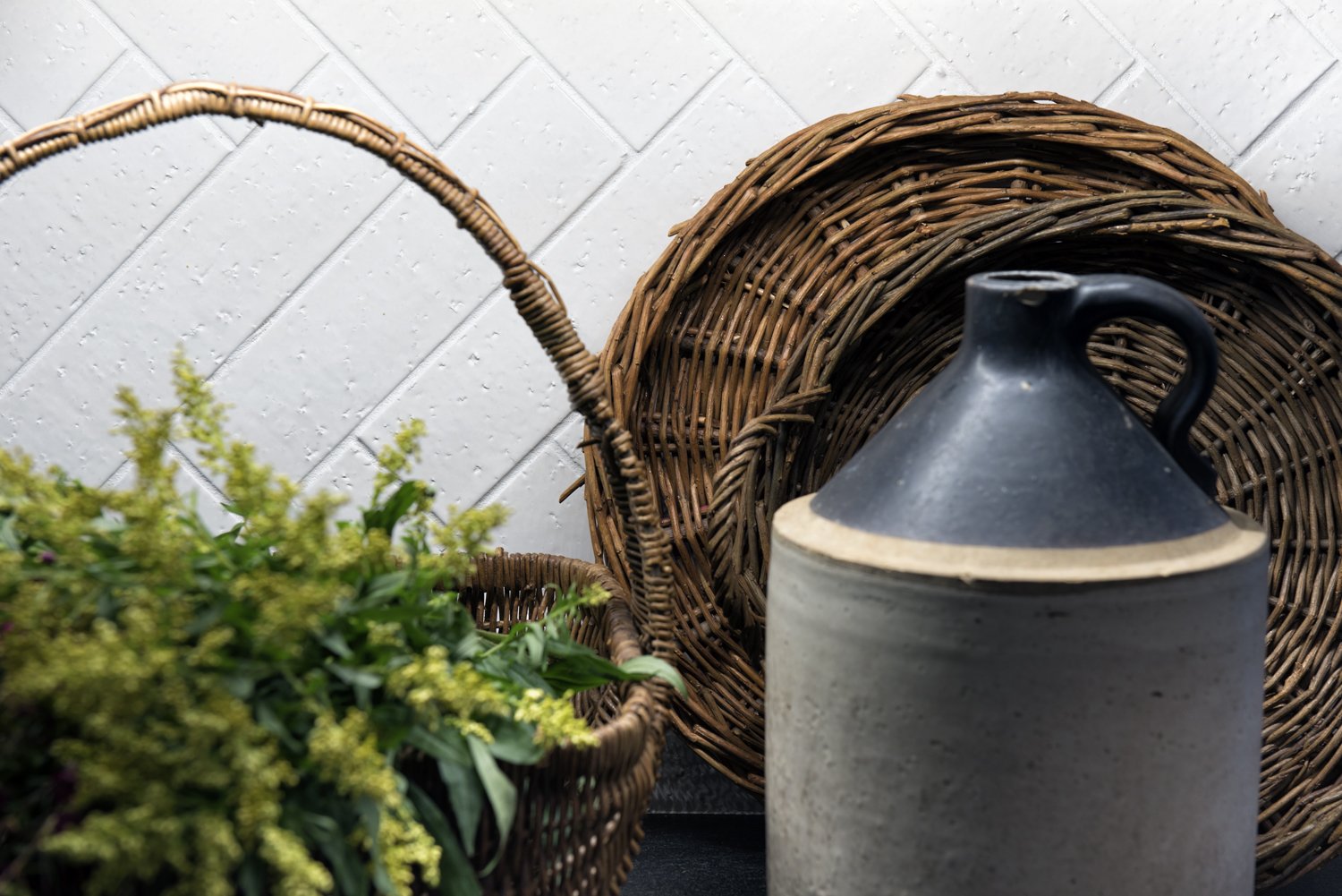  A close-up of a styled countertop with wicker baskets and ceramics.  