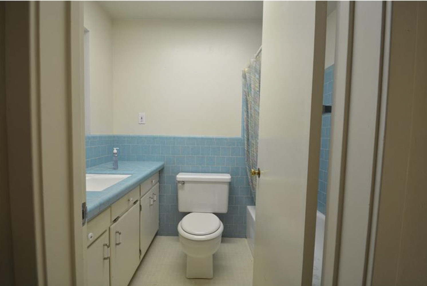  Before image of a bathroom with blue tile.  