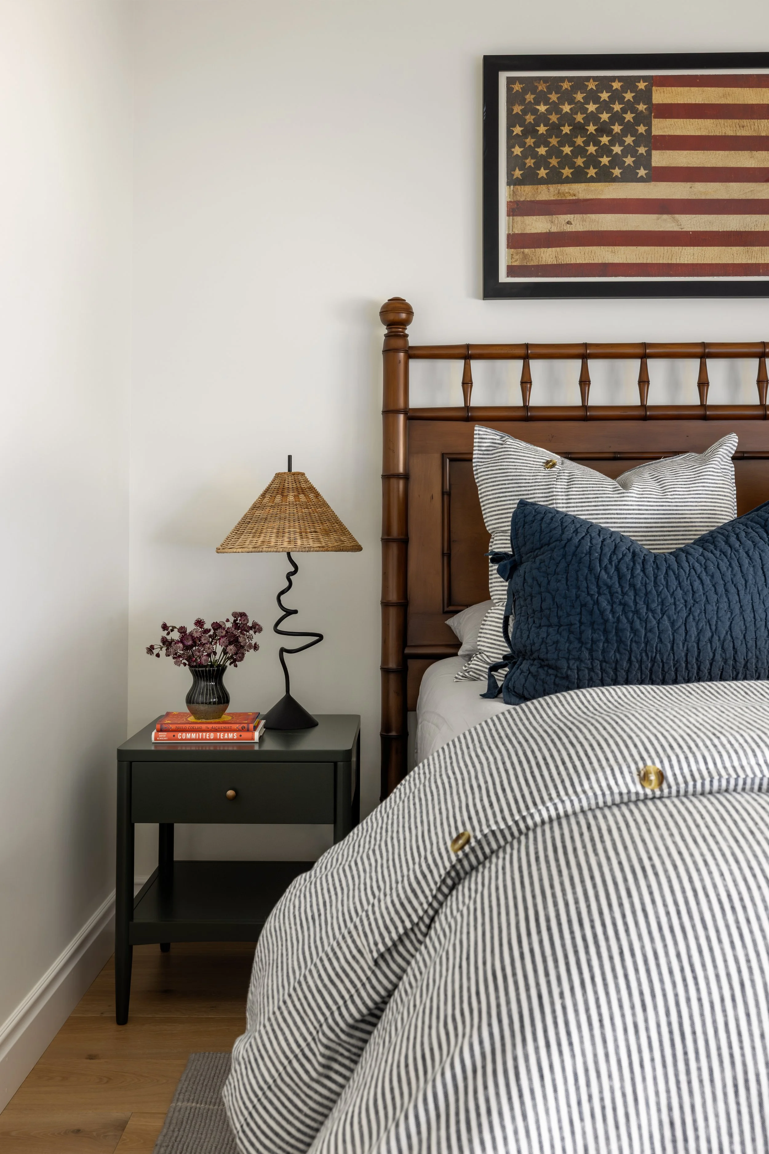 Boys bedroom nightstand detail with rattan lamp, dark wood spindle bed, and striped bedding — Bartlett Residence by Tama Bell Design, Ukiah CA