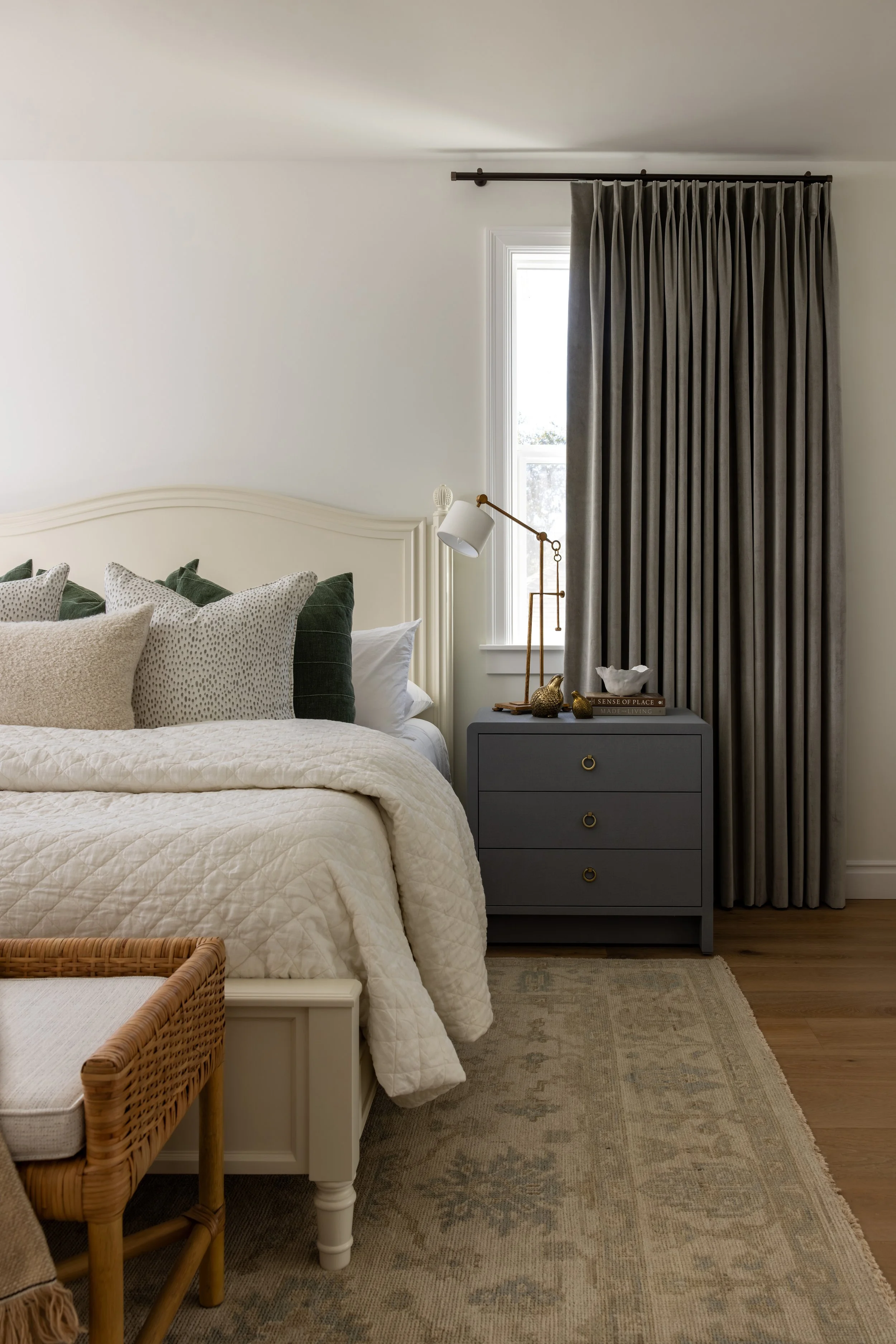 Guest bedroom detail with gray three-drawer nightstand, brass task lamp, and layered neutral bedding — Bartlett Residence by Tama Bell Design, Ukiah CA