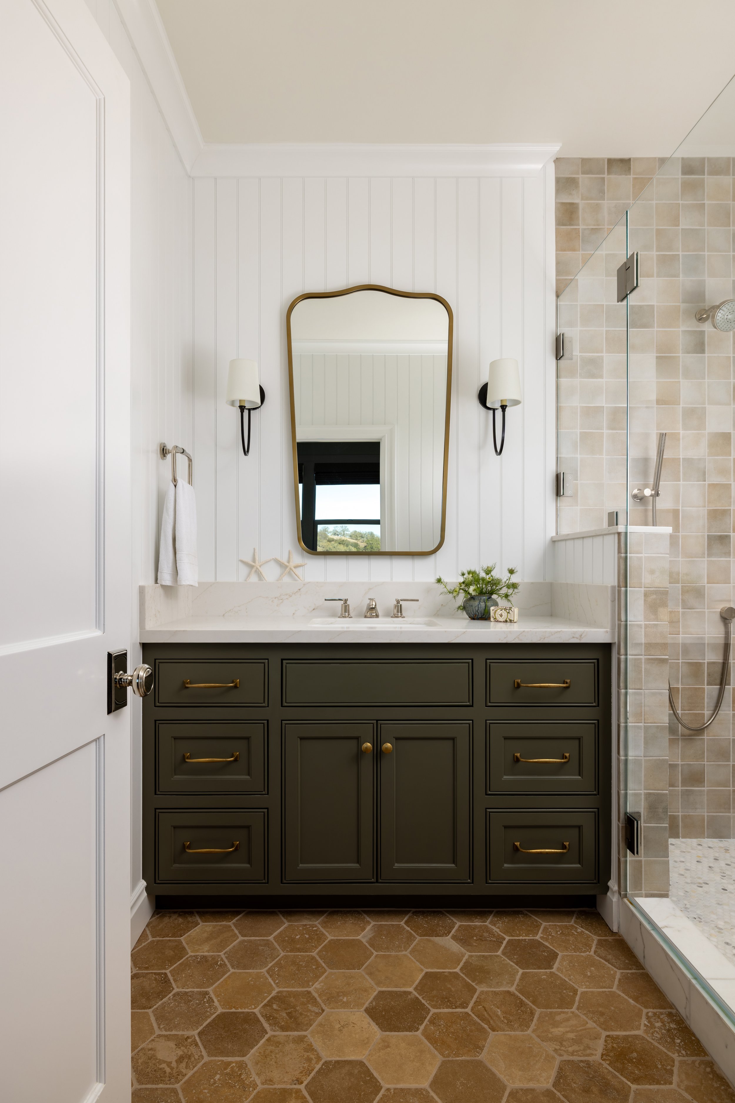 Boys bathroom with dark olive vanity, brass hardware, gold arched mirror, shiplap wall, and hexagon tile floor — Bartlett Residence by Tama Bell Design, Ukiah CA