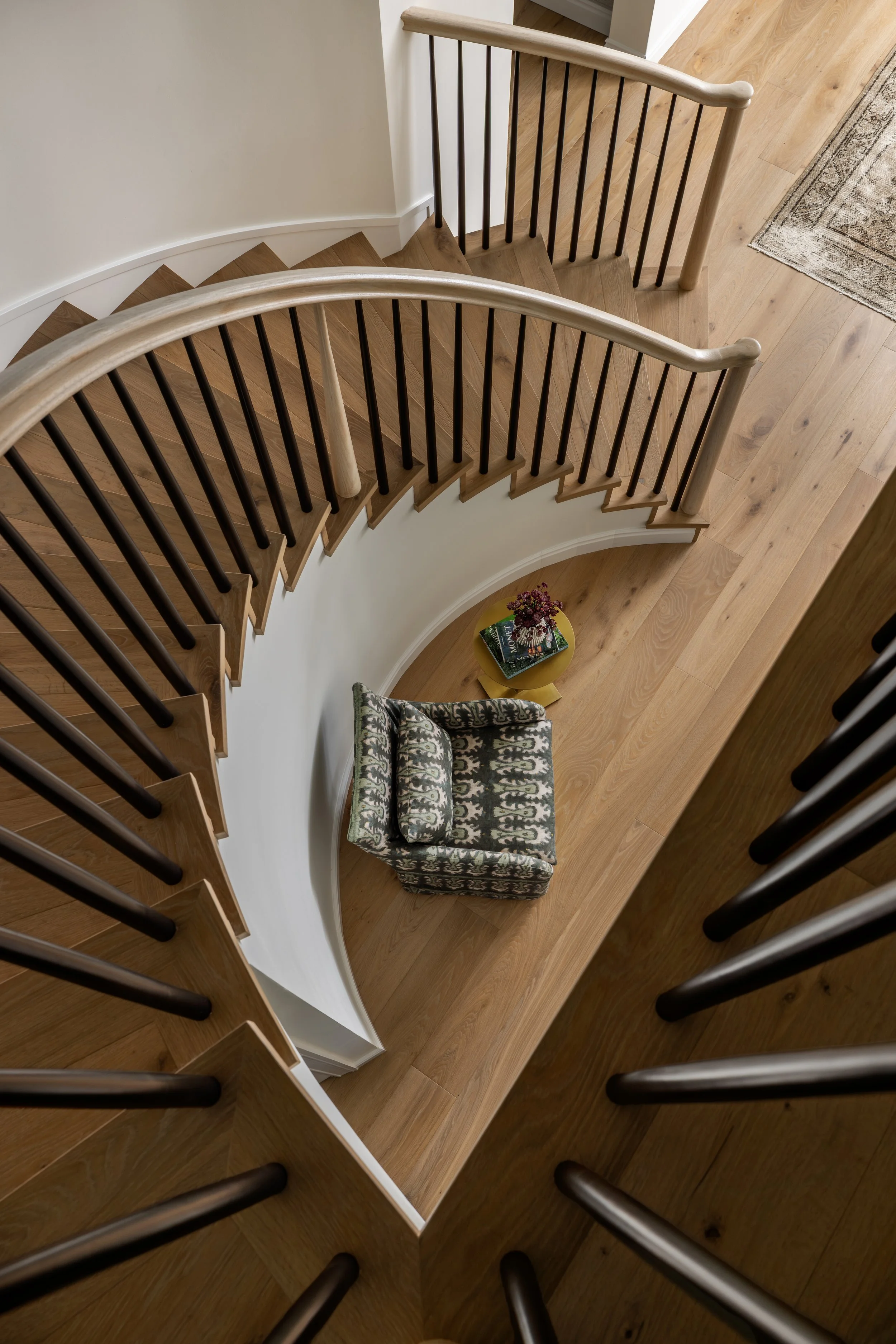 Transitional entryway with curved wood staircase and patterned armchair — Bartlett Residence by Tama Bell Design, Ukiah CA