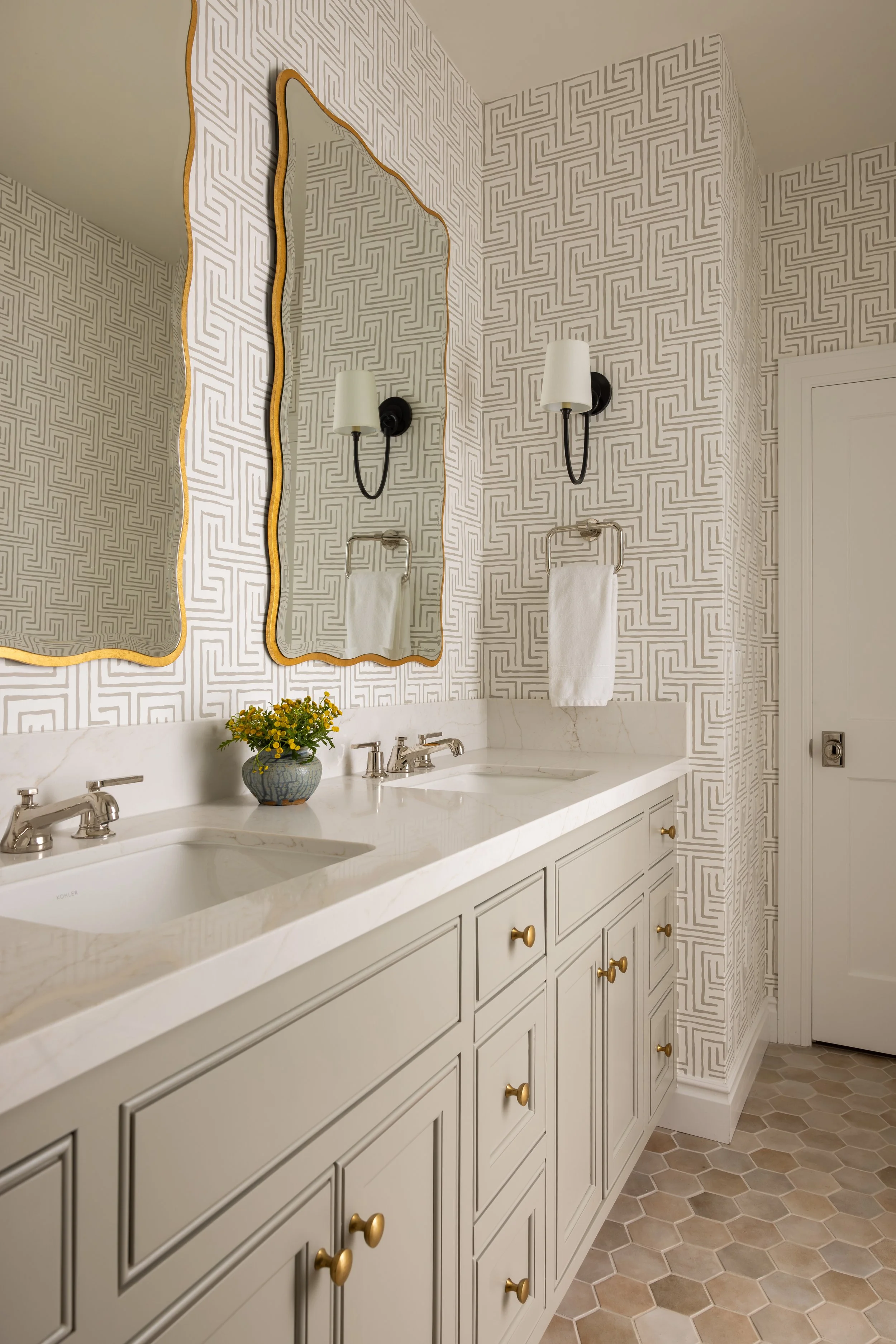 Double vanity bathroom with bold geometric wallpaper, gold wavy mirror, black sconces, and marble countertop — Bartlett Residence by Tama Bell Design, Ukiah CA