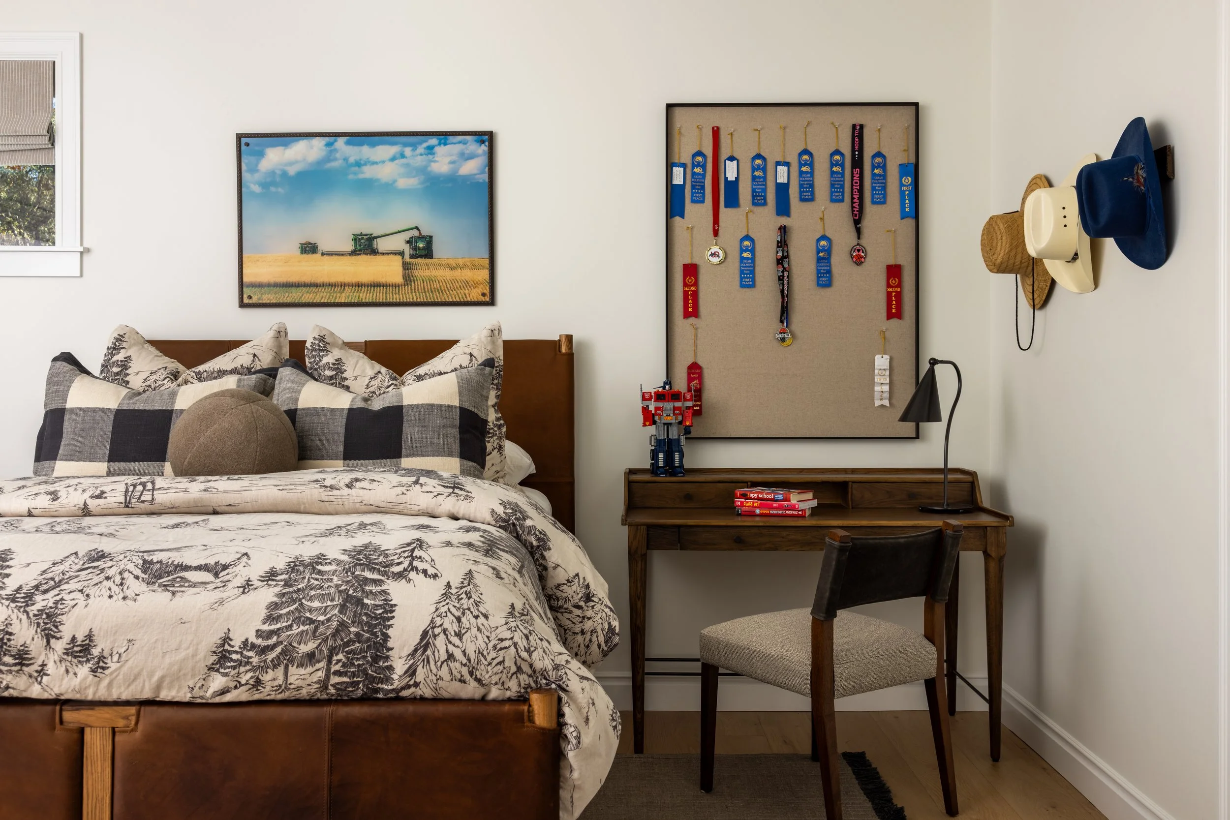 Boys bedroom with leather bed frame, forest print bedding, wood desk, and ribbon display board — Bartlett Residence by Tama Bell Design, Ukiah CA