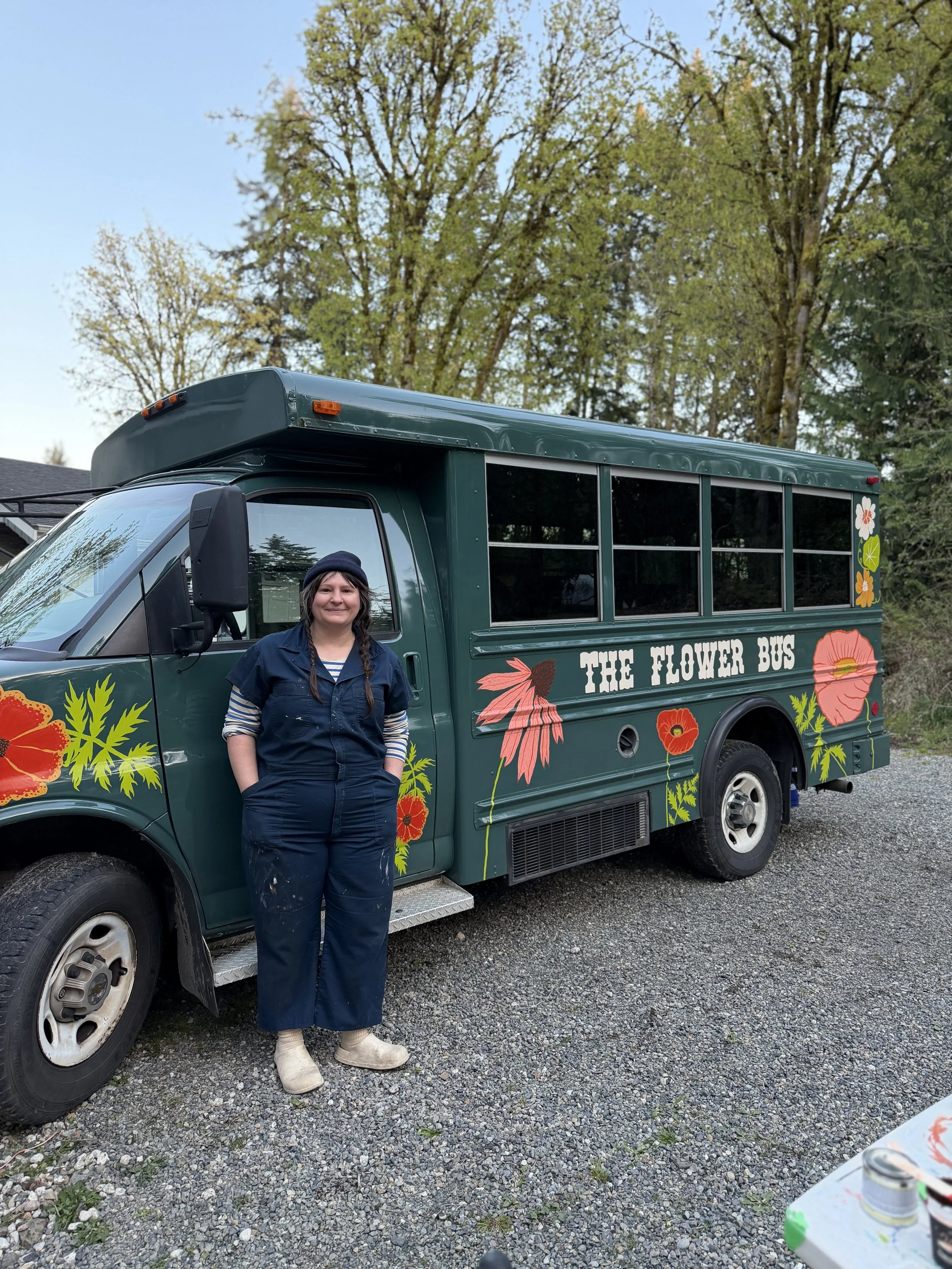 Molly Wheat Baker standing by the newly finished mural on The Flower Bus!