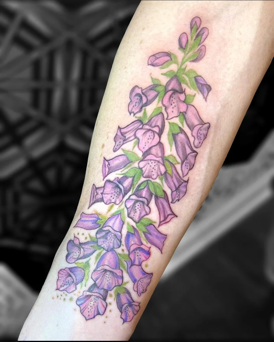 Tattoo of purple foxglove flowers on forearm.