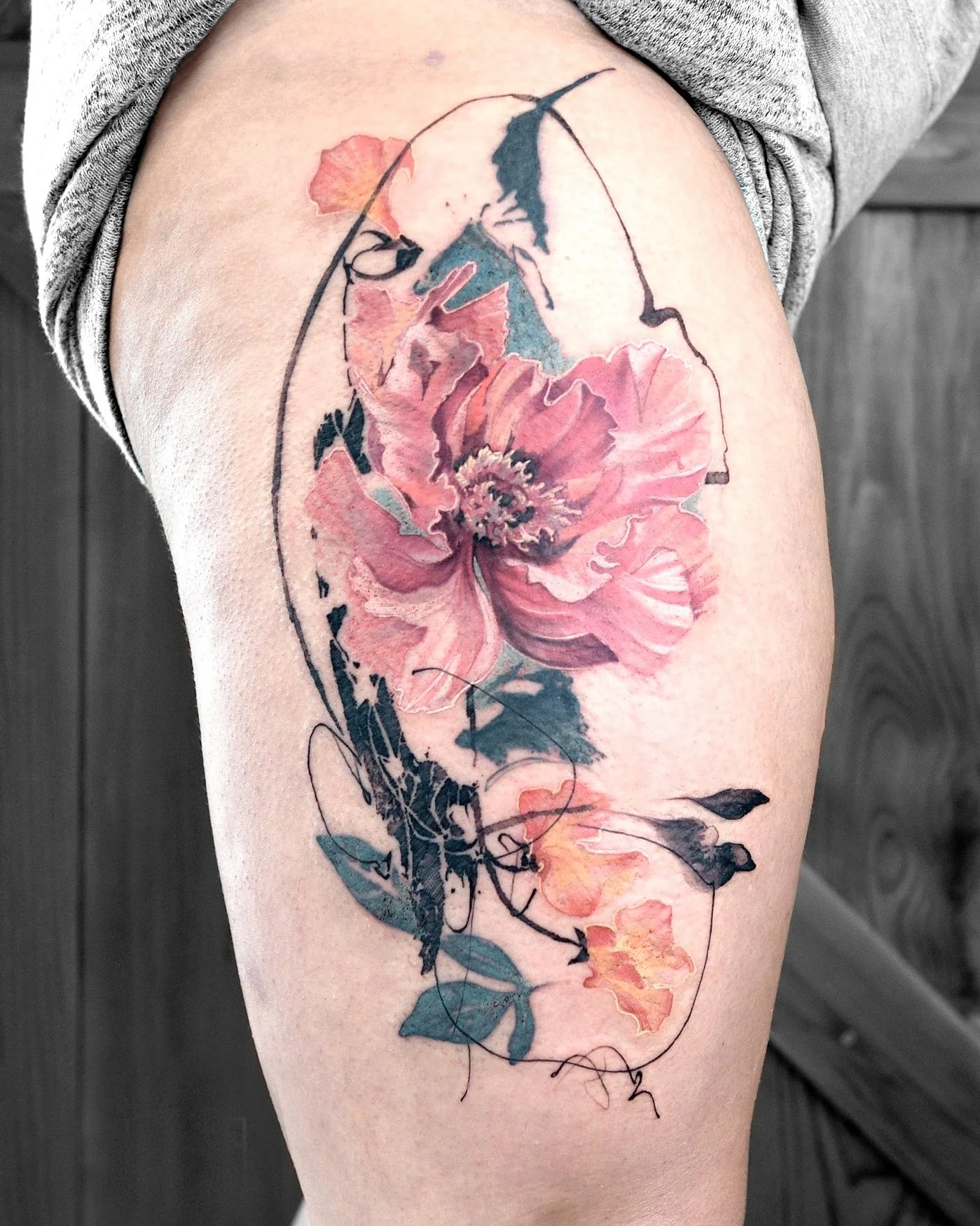 Floral tattoo on arm with abstract design and pink flowers.