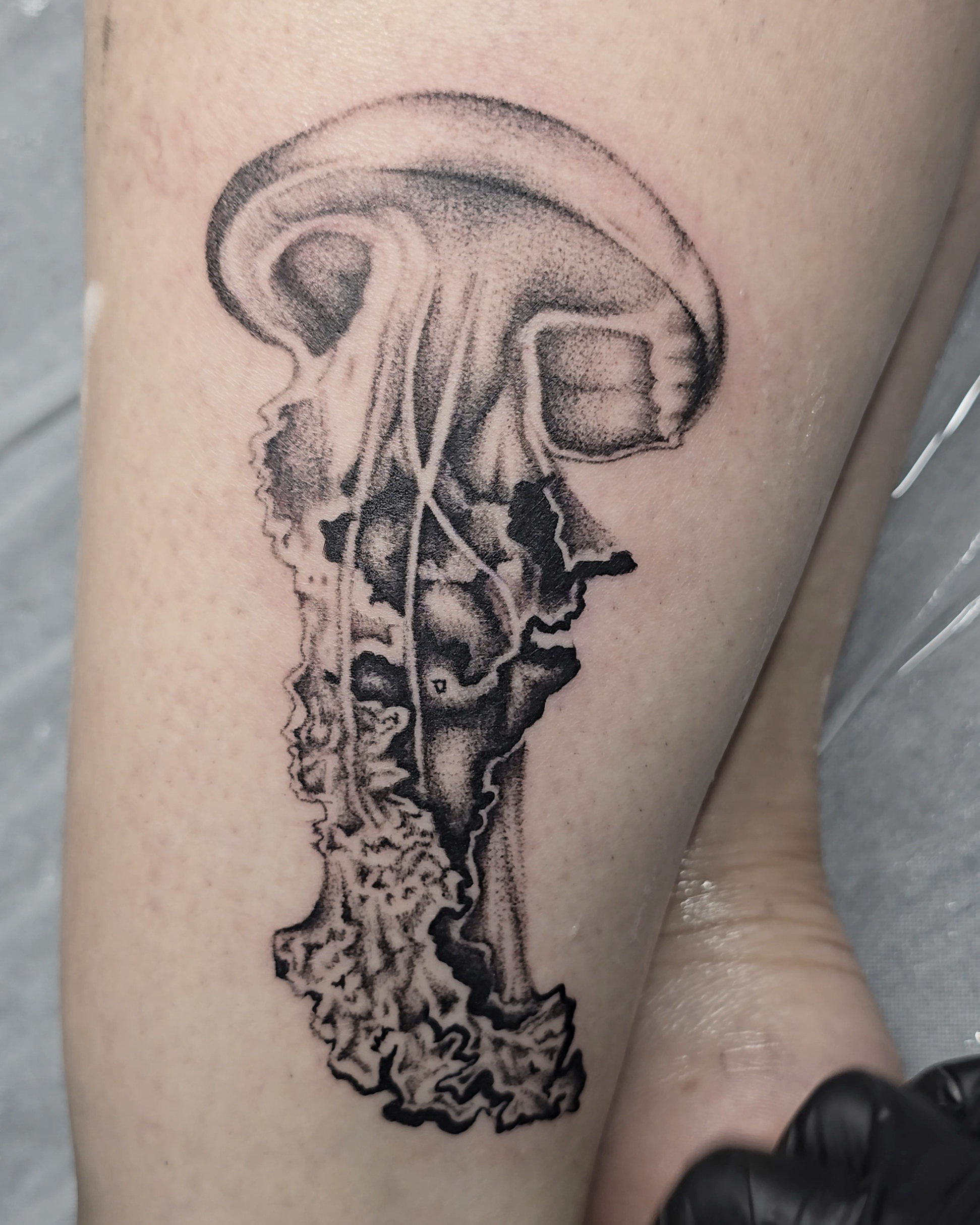 Black and gray jellyfish high realism tattoo on a thigh.