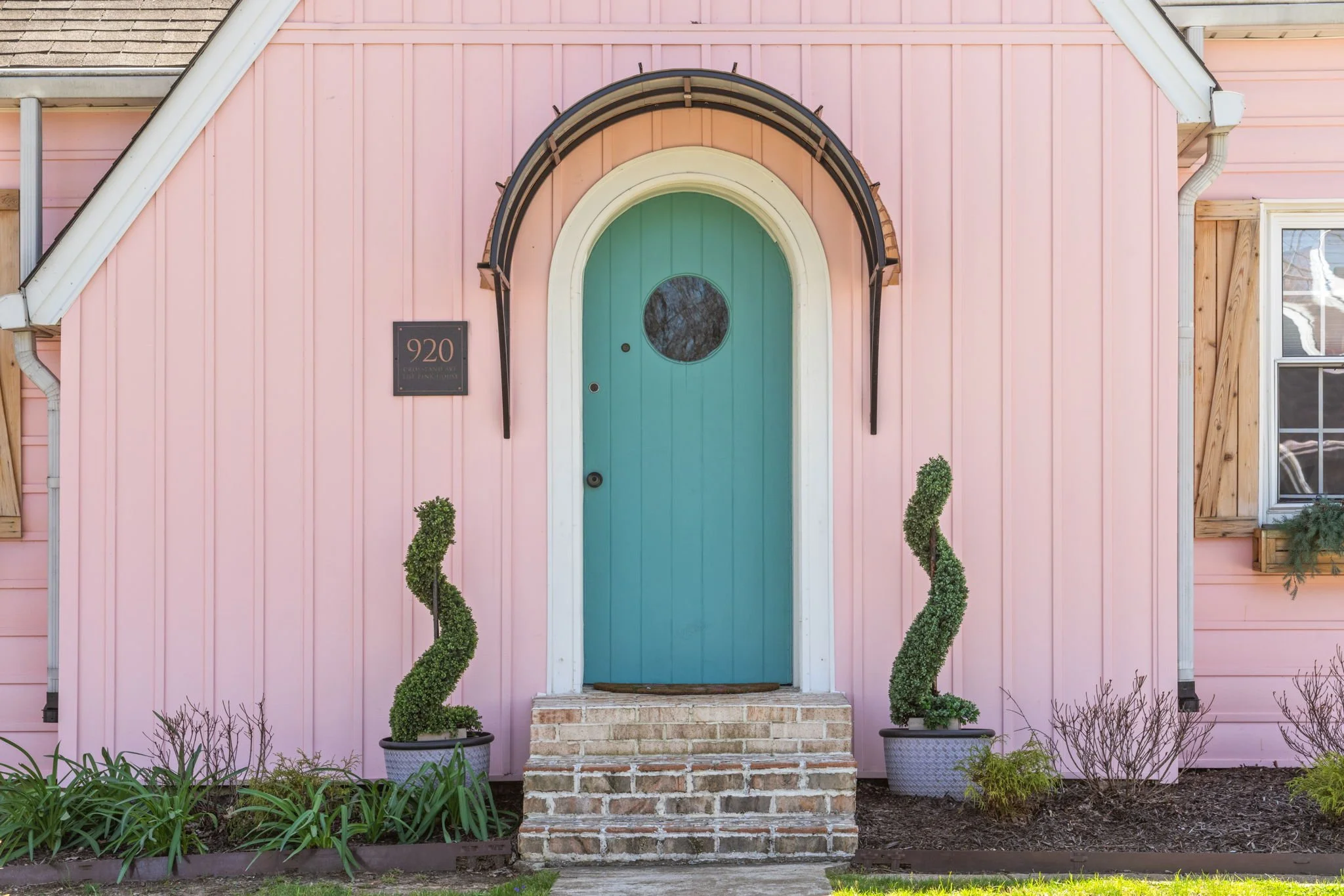 Indoor game room with a pool table, orange chairs, and a wall clock, with a small sofa and framed posters in the background.