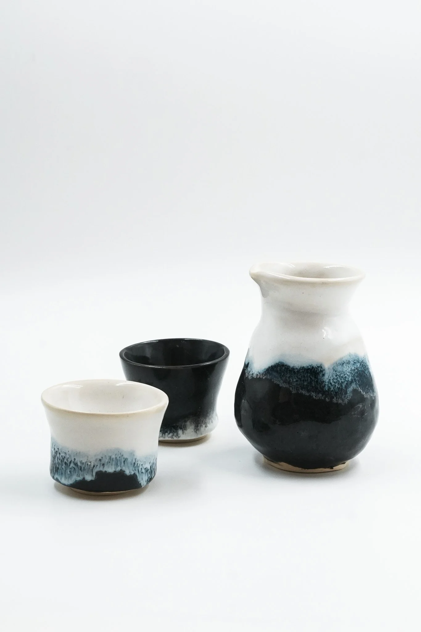 A person is holding a ceramic bowl with a speckled beige interior and dark exterior against a plain white background.