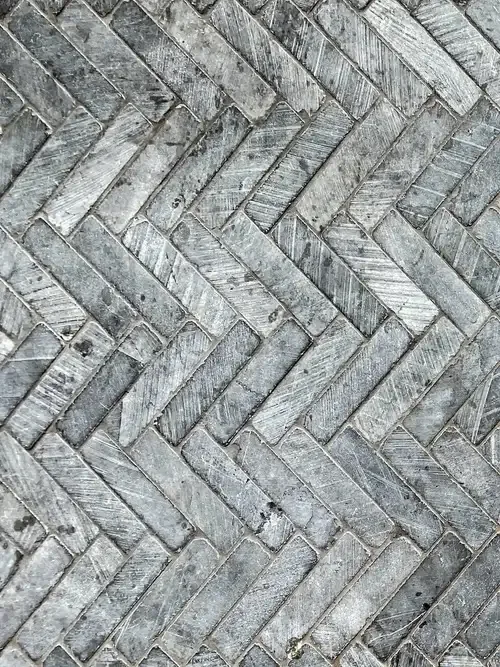 Closeup of repaired perpendicular outdoor tiles and grout