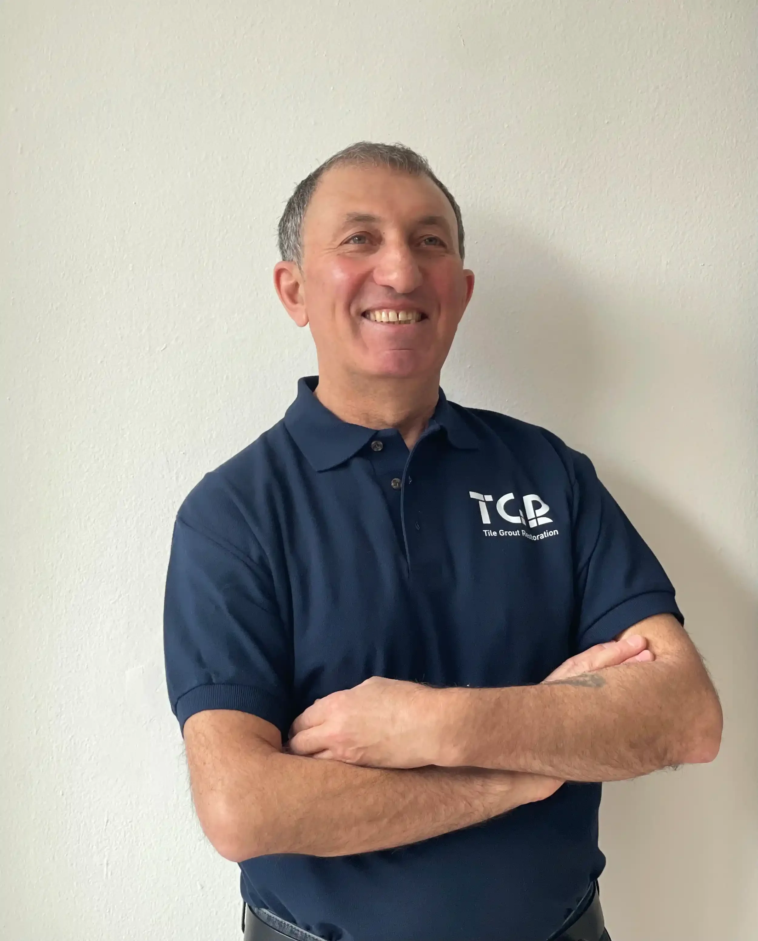 Owner of Tile Grout Restoration smiling with hands crossed.