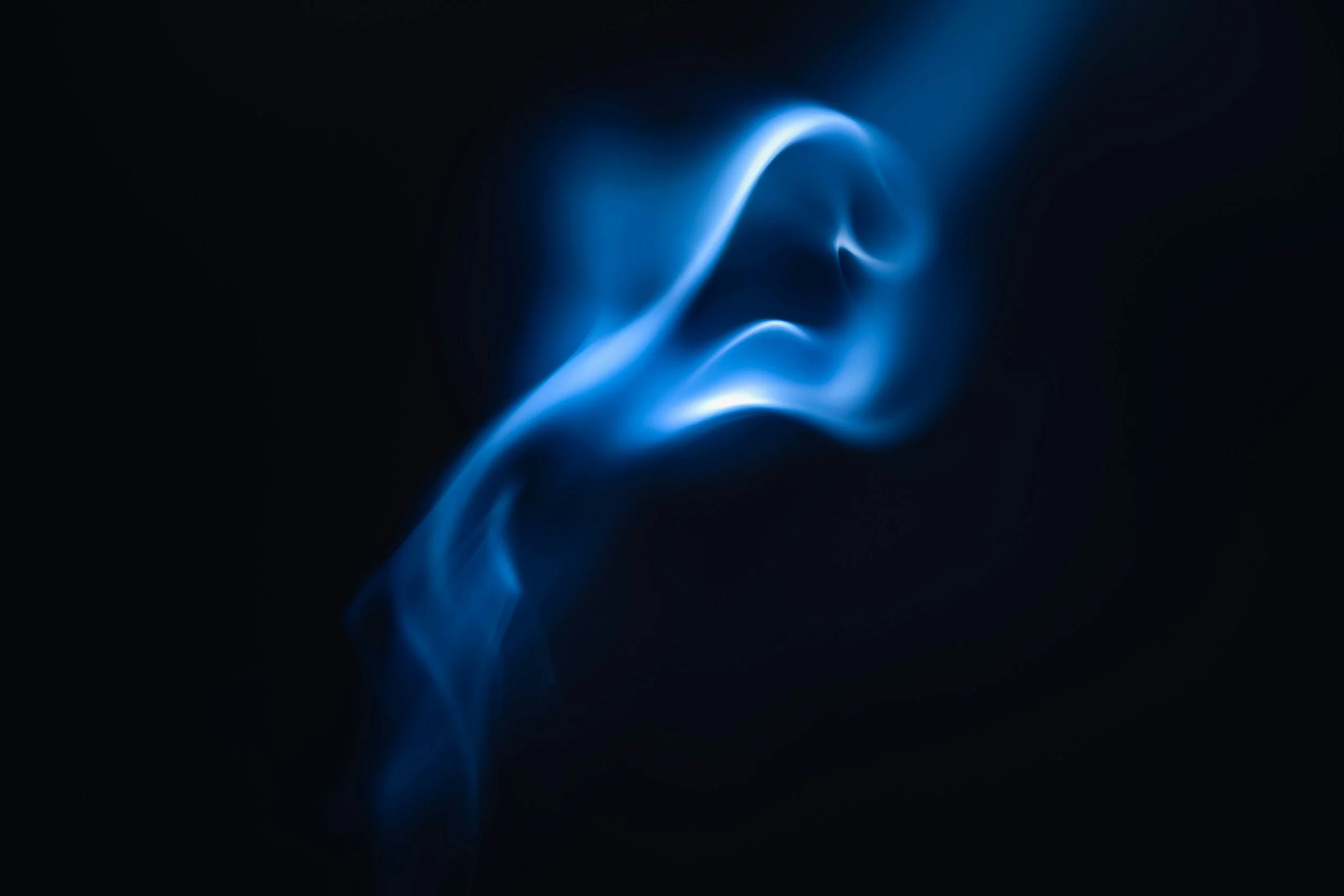 A bluish cloud floating against a black background