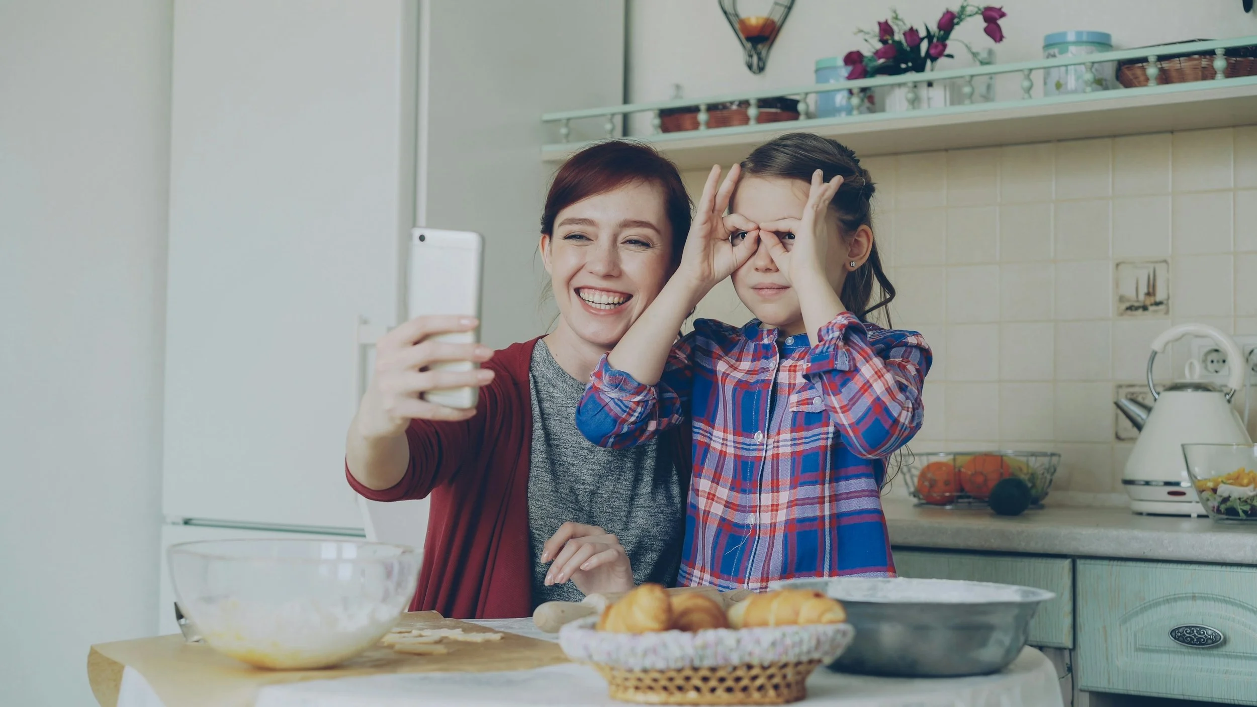 A mother and child with the mother taking a selfie with a smartphone