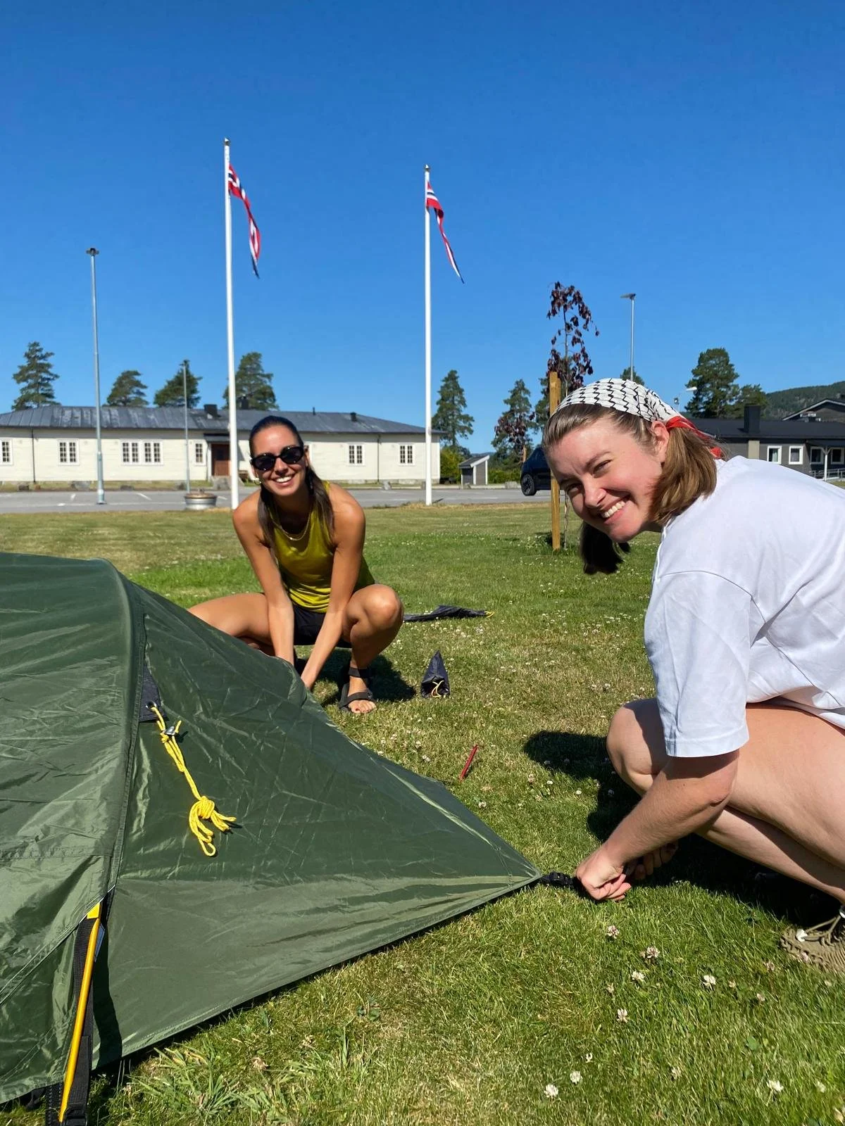 2 smiling participants practicing to set up tents