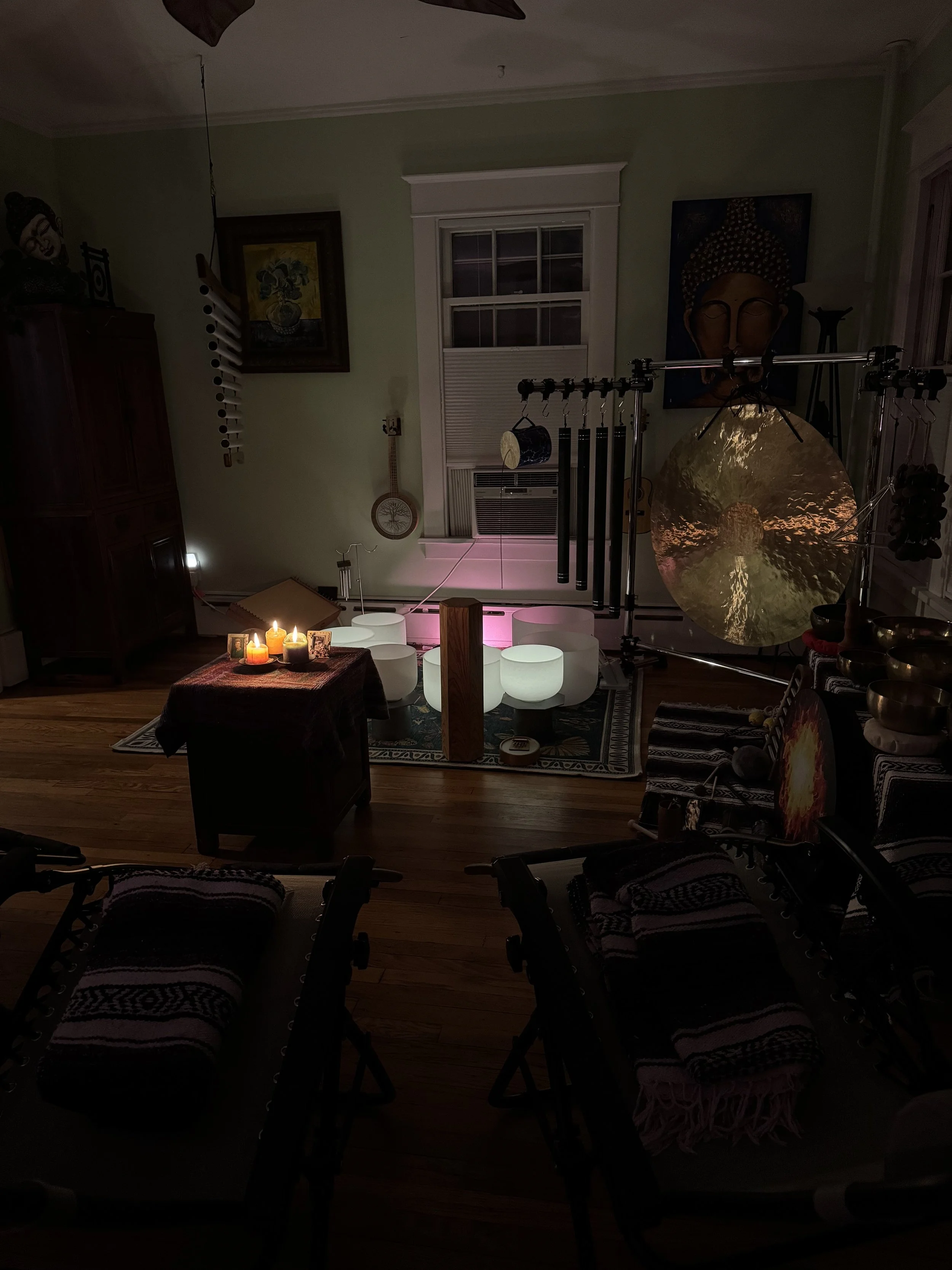 Indoor soundbath setup with crystal bowls, gong & chimes