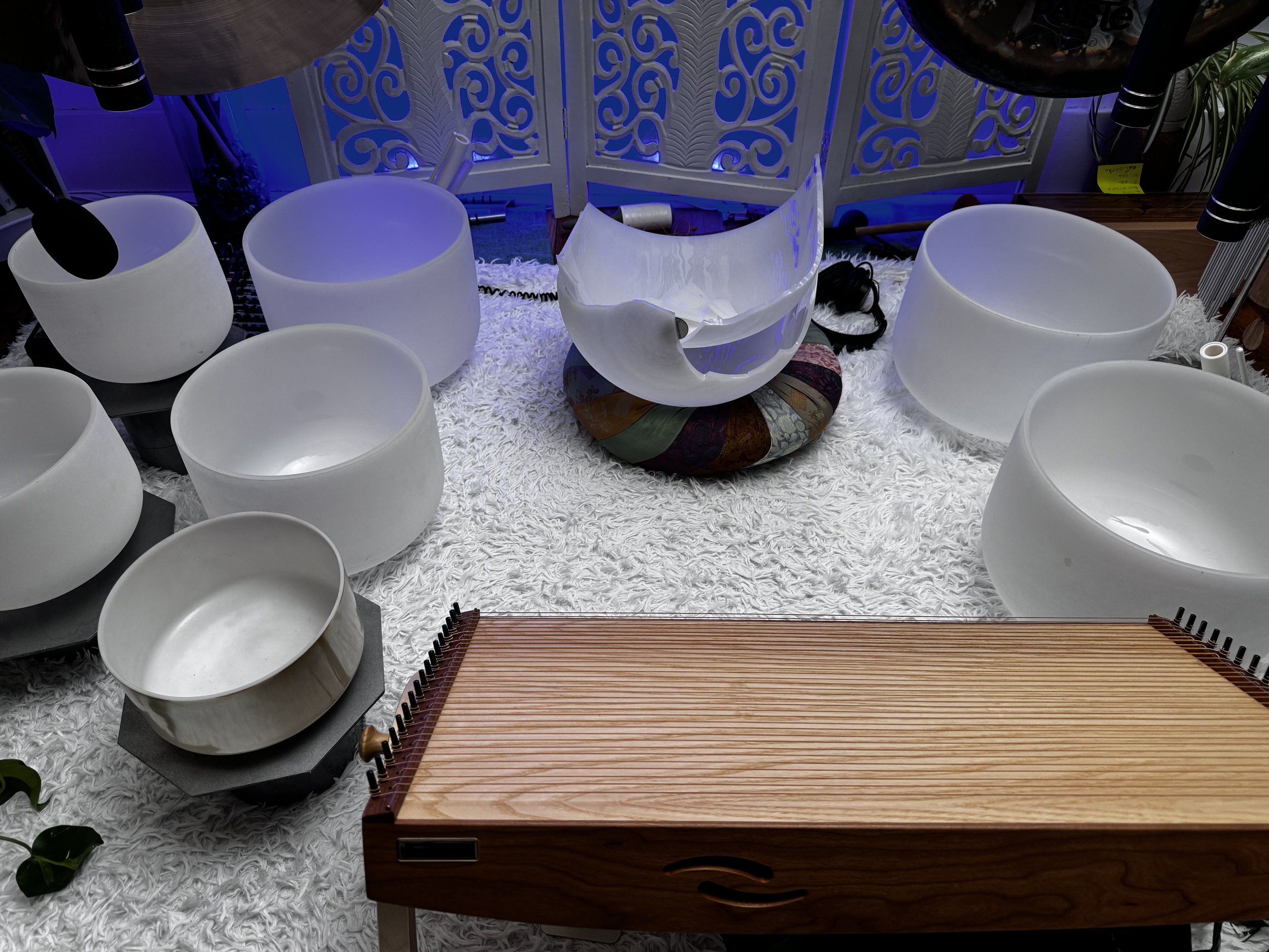 Photograph of a setup of crystal bowls with a large broken bowl in the center.