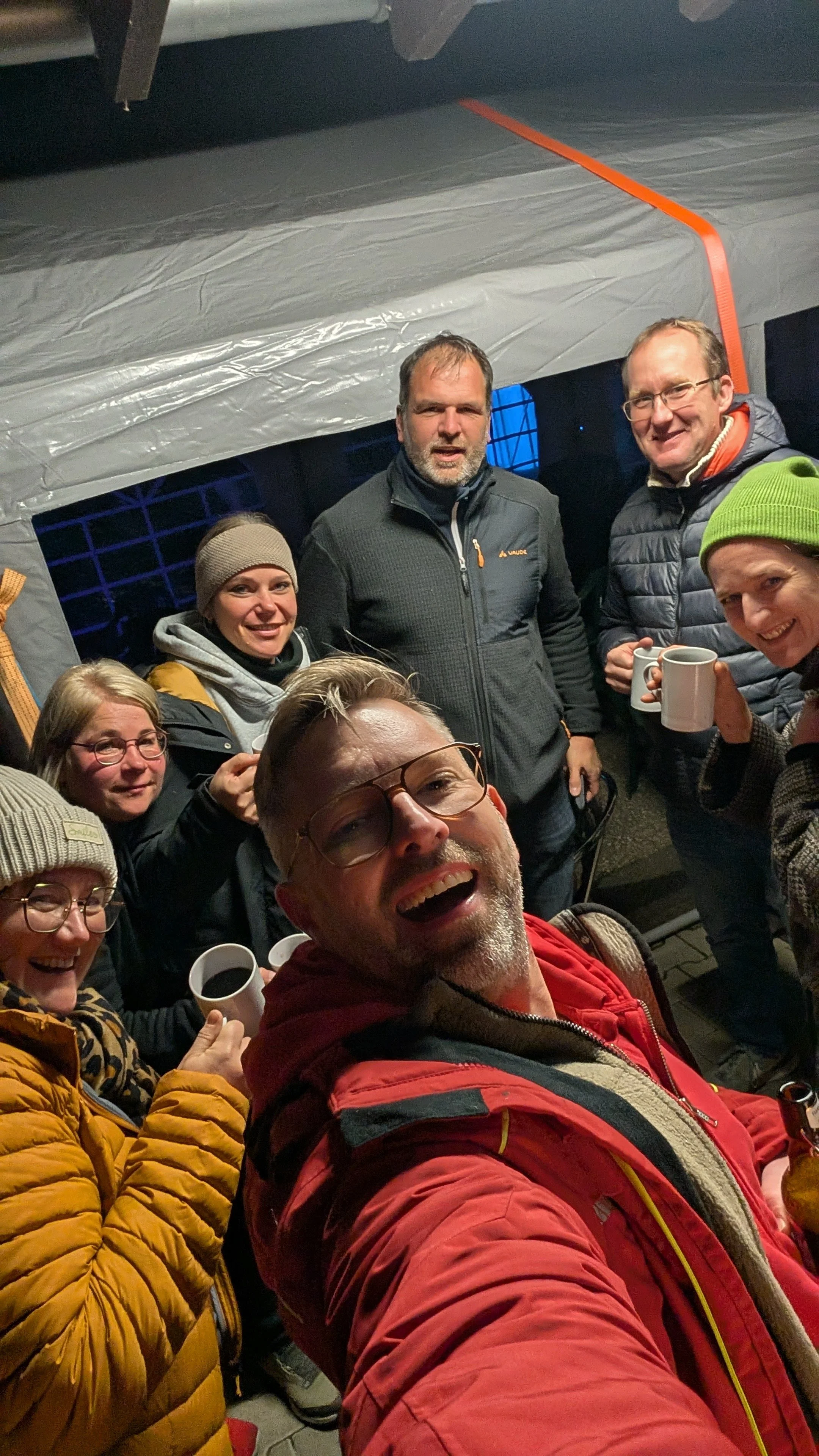 Gruppe von Menschen beim Saisonabschluss mit Glühwein.