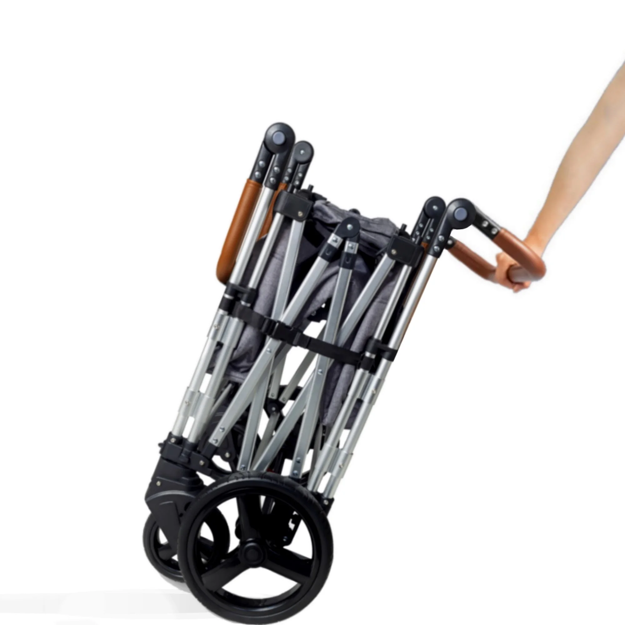 A lightweight folded portable baby stroller wagon being pushed by a person's hand.