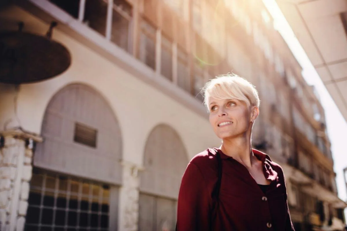 Woman looking up thoughtfully in golden afternoon light, representing clarity and a renewed sense of self