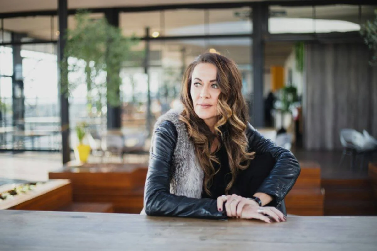 A woman leaning in the table while sitting