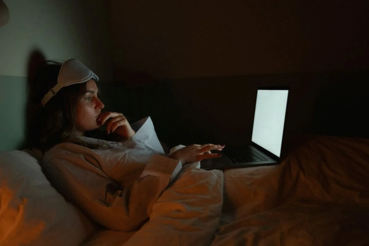 Woman using a laptop in bed