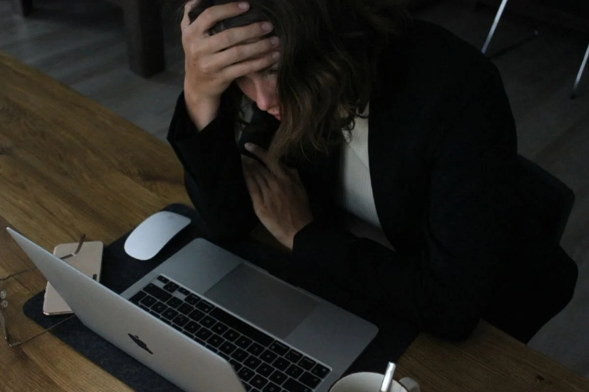 A woman stressing while looking at the laptop