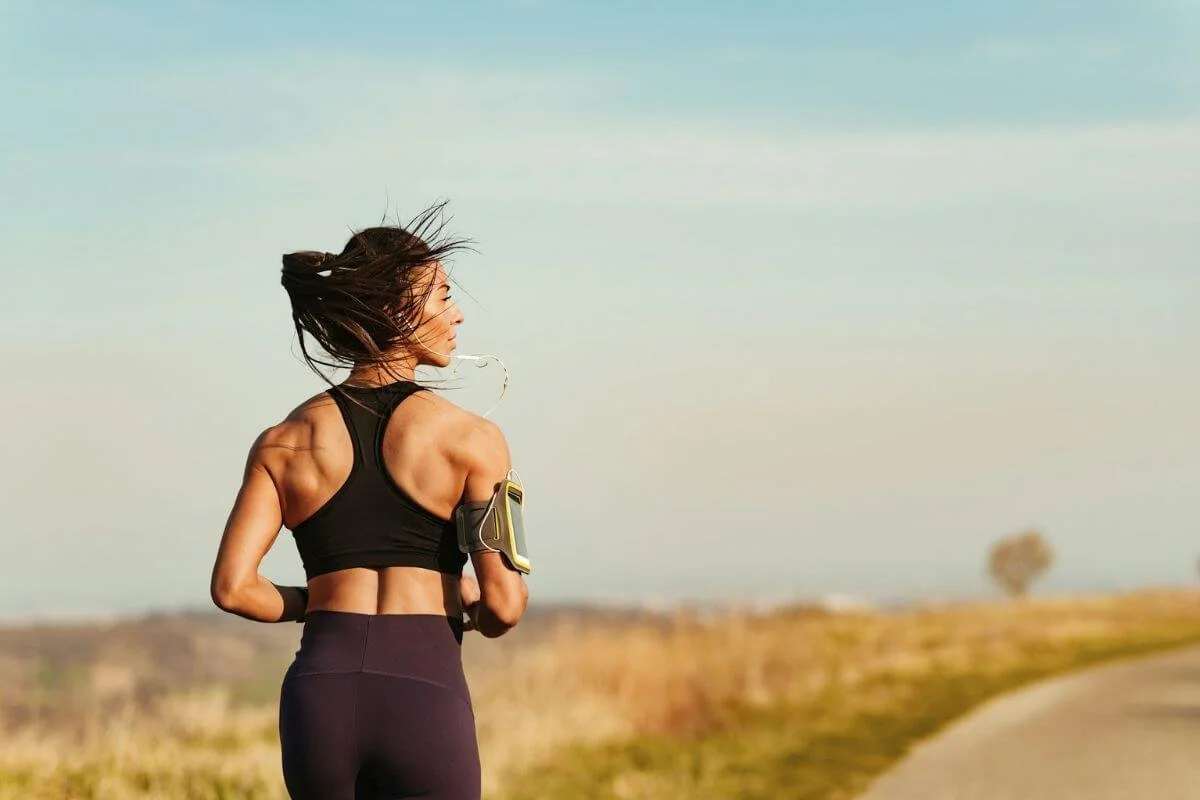 Woman jogging outdoors to support physical vitality and energy