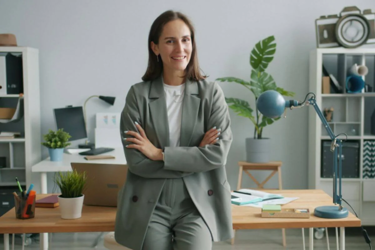 A woman leaning against the table with her arms crossed