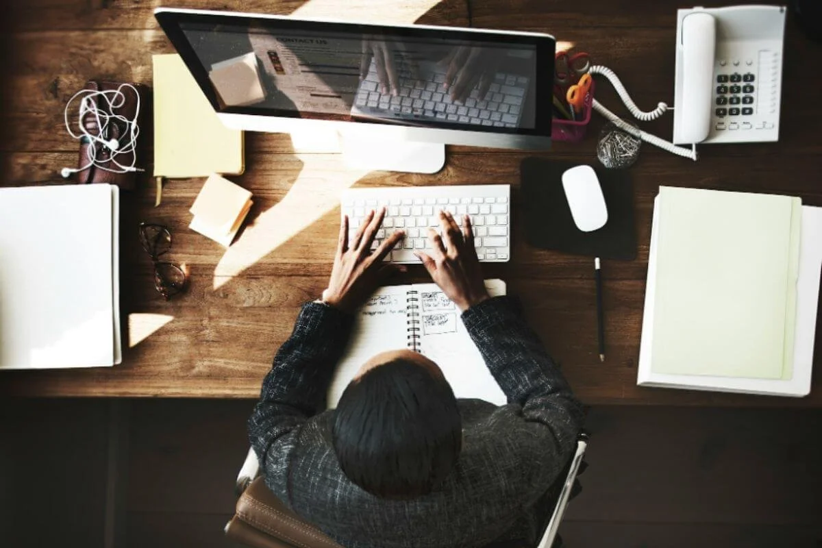 Overhead view of a busy desk, representing decision fatigue, work pressure, and feeling overwhelmed