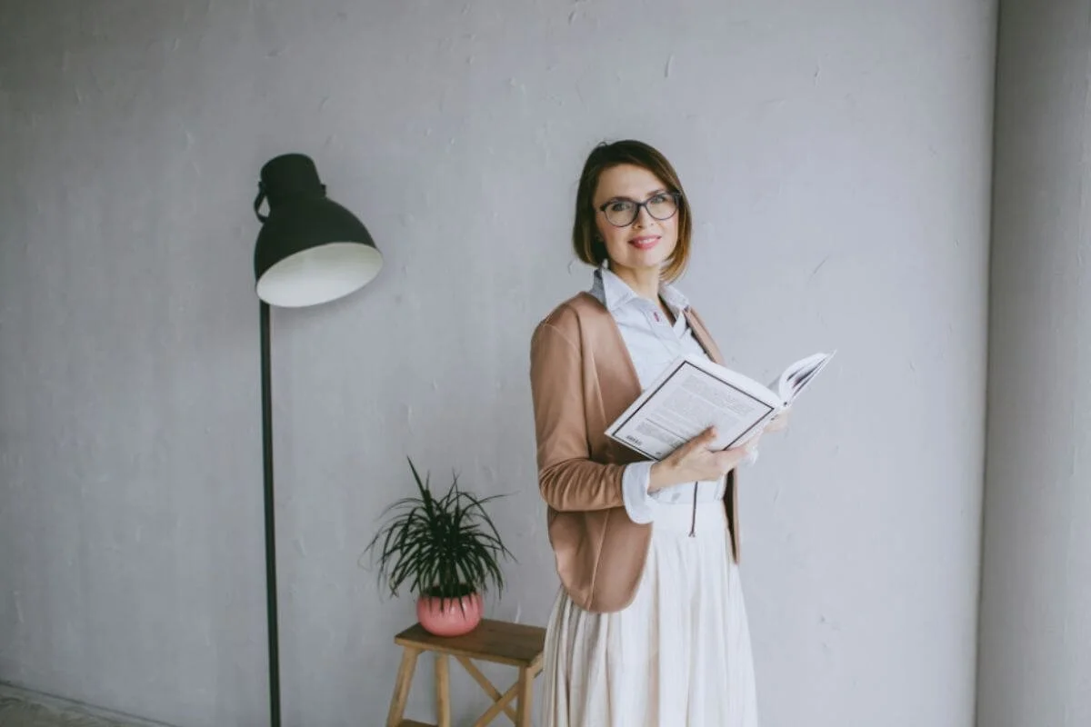 A woman holding a book in a home setting