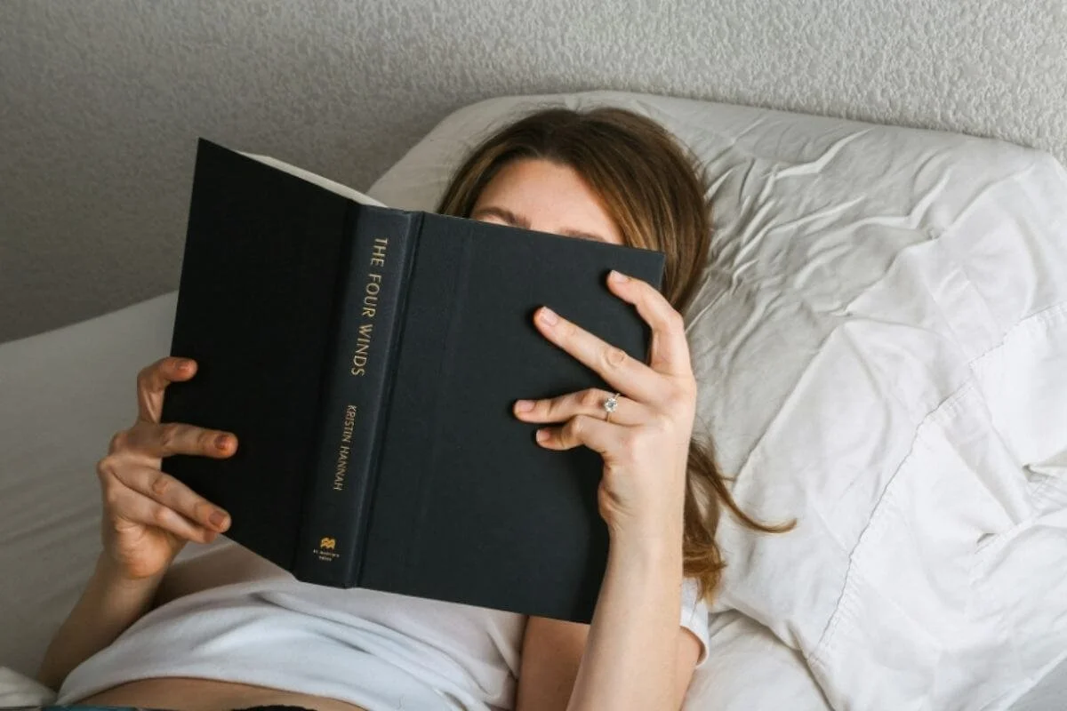 Woman reading a book in bed