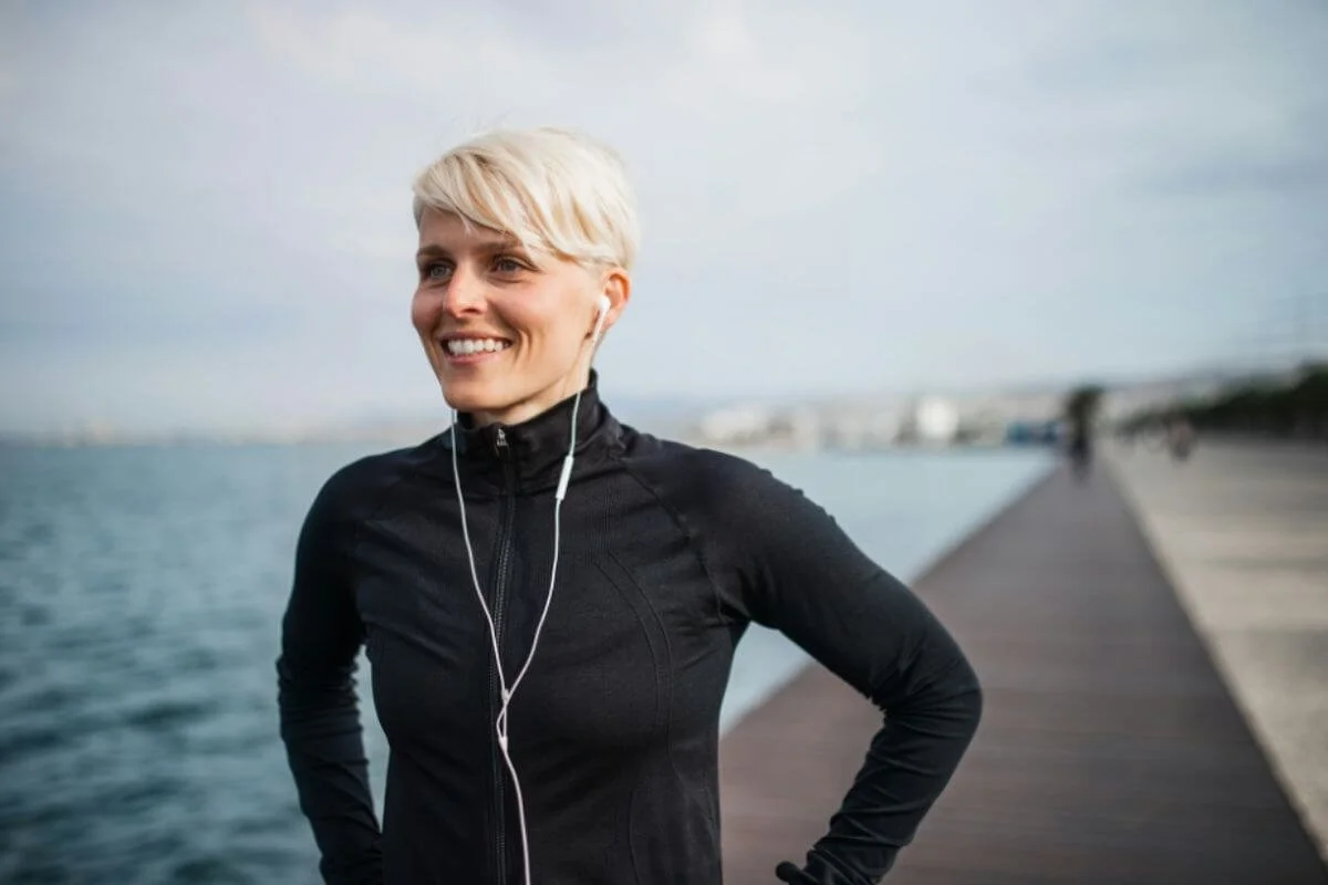 A woman smiling while jogging