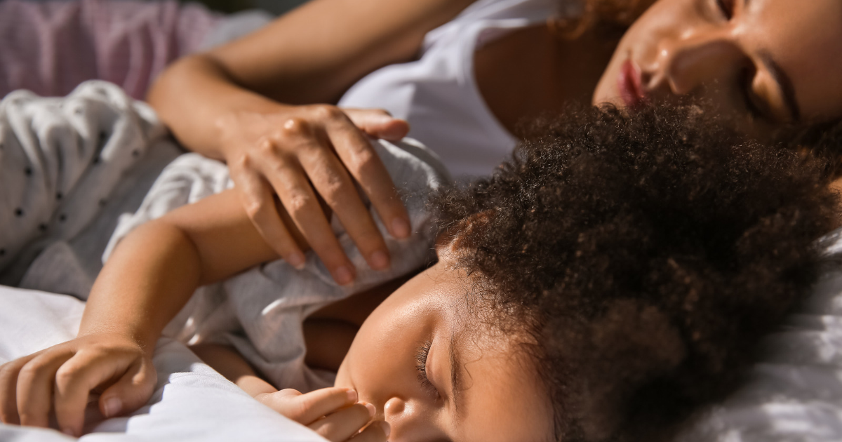 Mom and toddler sleeping closely together in bed, a toddler who won't sleep alone without a parent close by