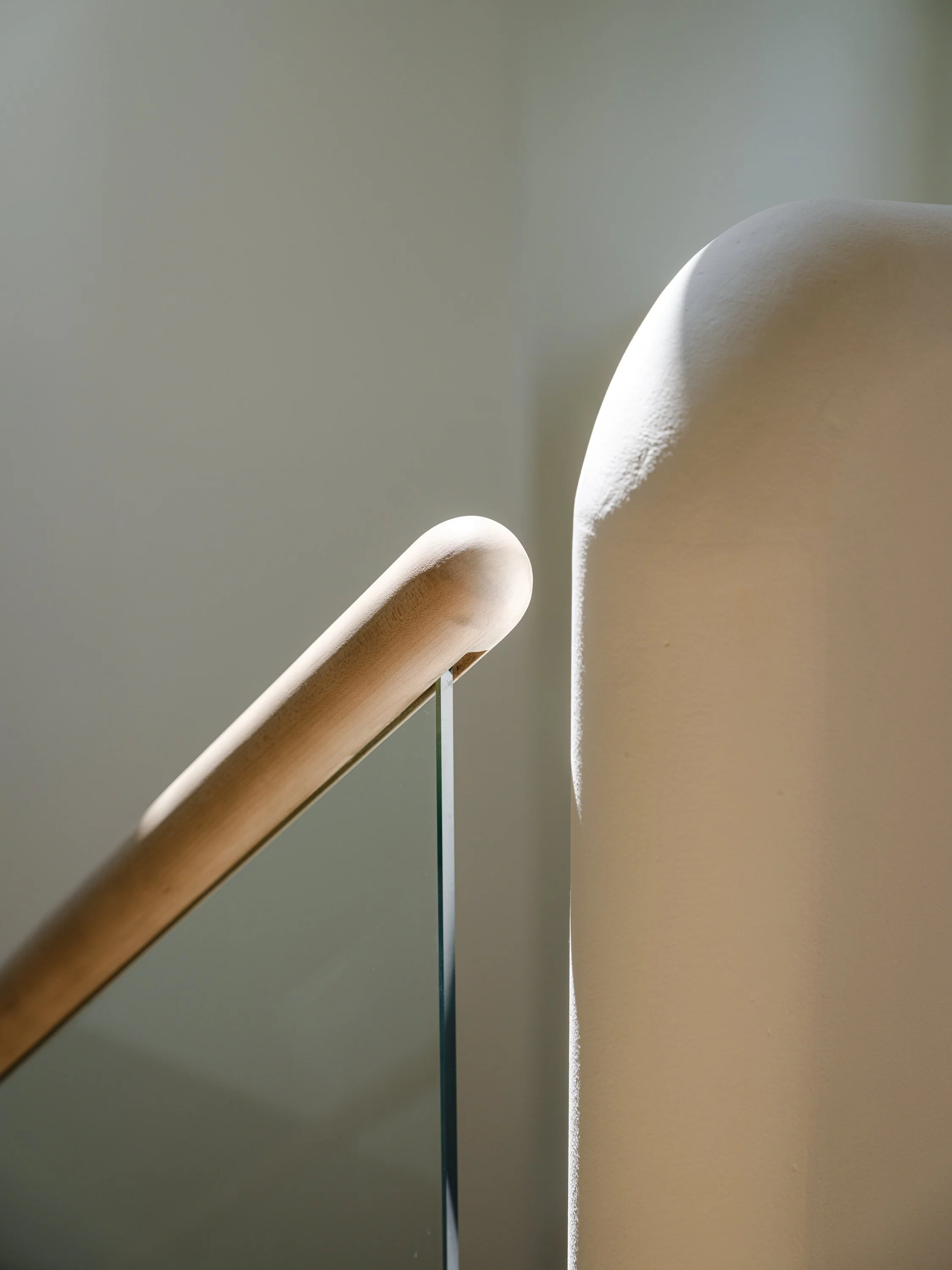 Détail de la main courante courbée en érable sur verre, façonnée sur mesure par StairPro.