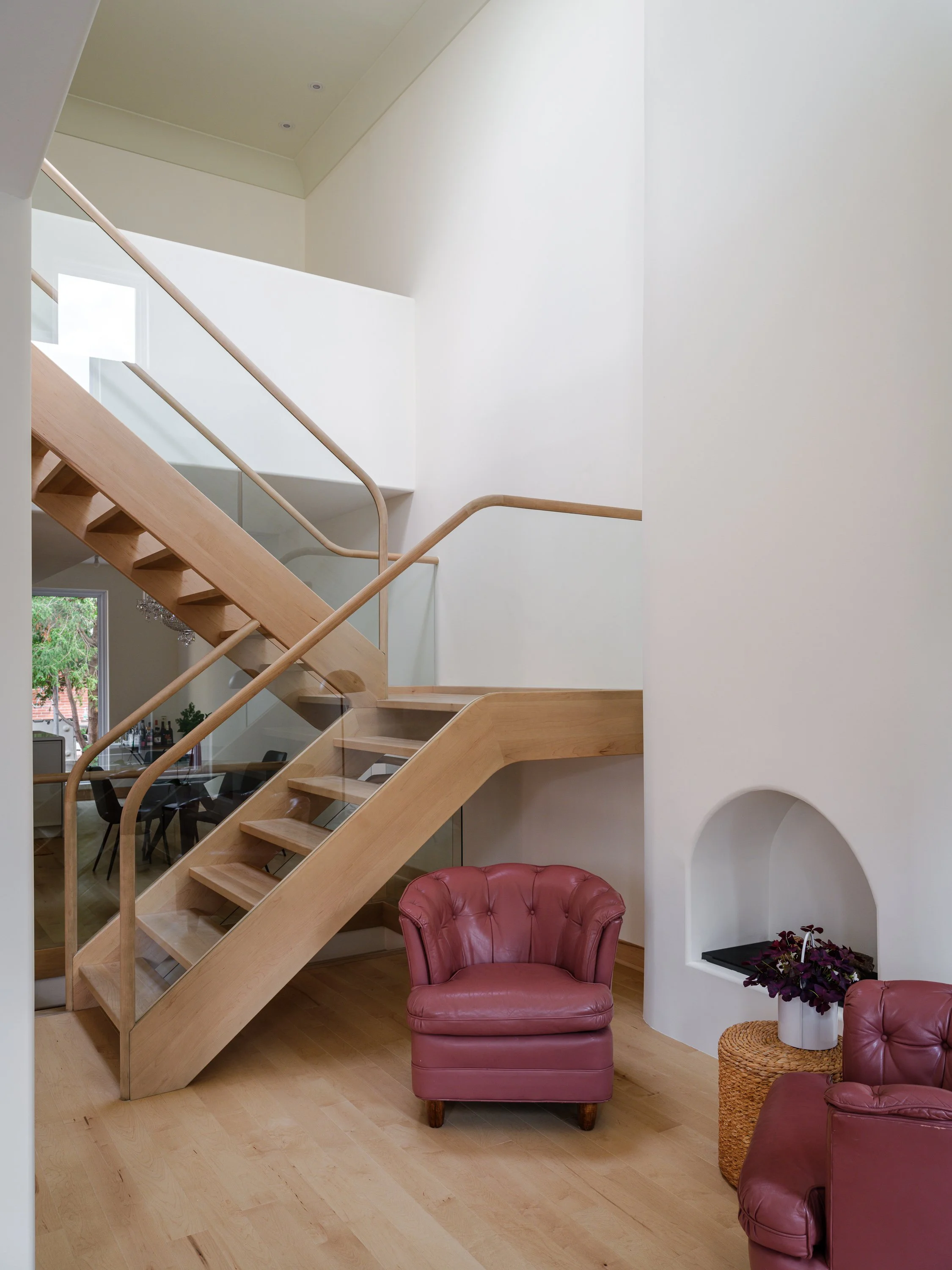 Vue d’ensemble de L’escalier de l’artiste, aux lignes courbes, avec garde-corps minimalistes en verre.