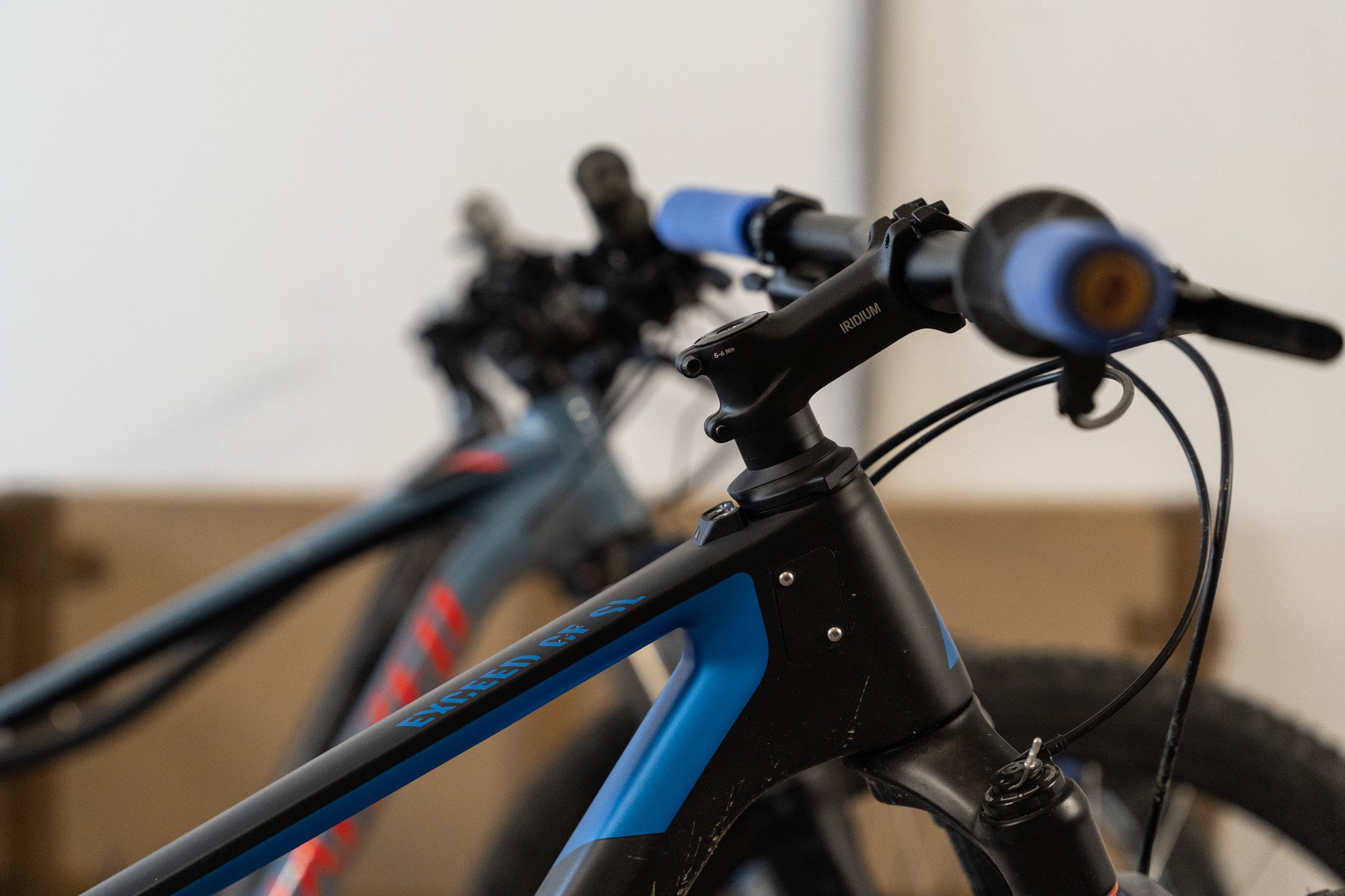 Nahaufnahme eines schwarzen und blauen Mountainbikes mit Fokus auf den Rahmen und den Lenker.