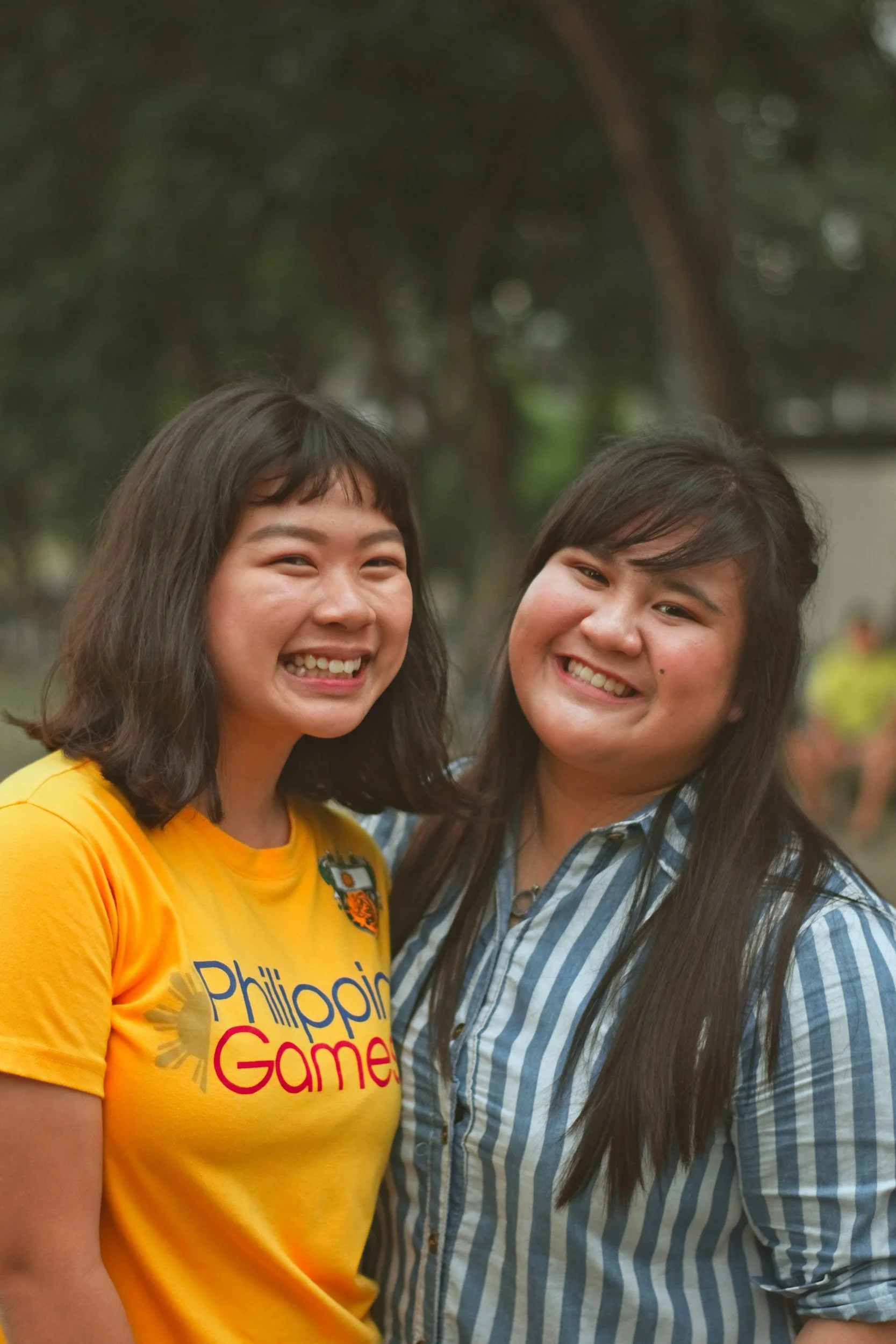 two girls with black hair smiling