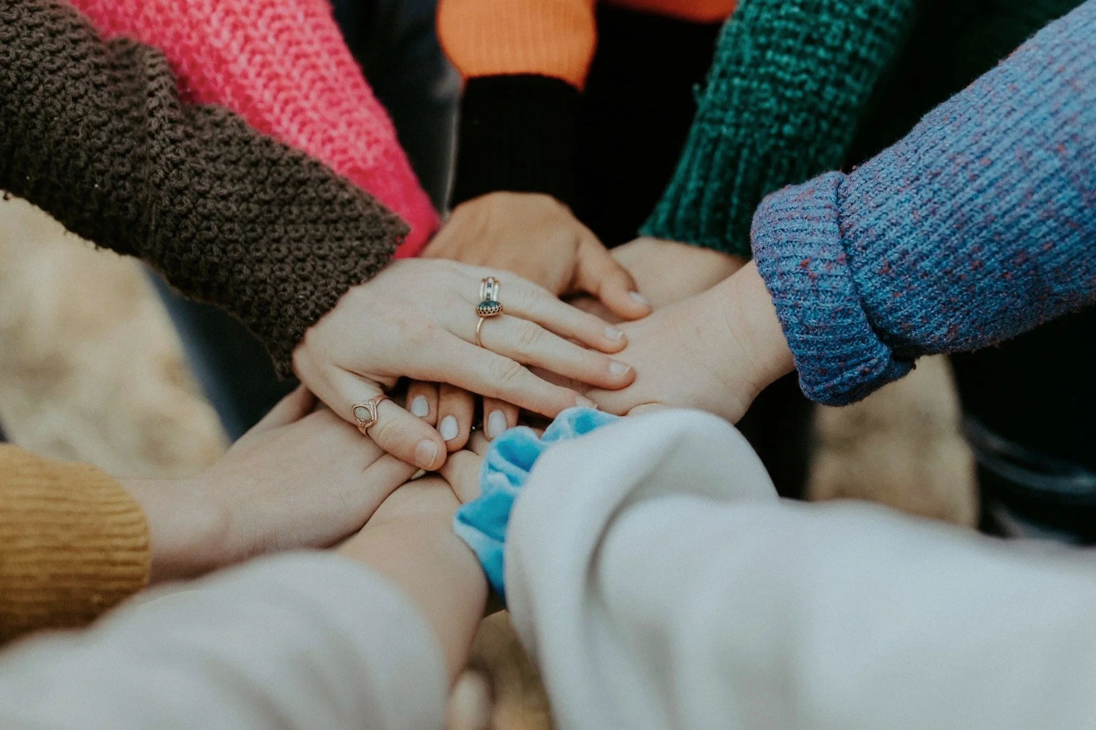 Many peoples’ hands on top of each others’