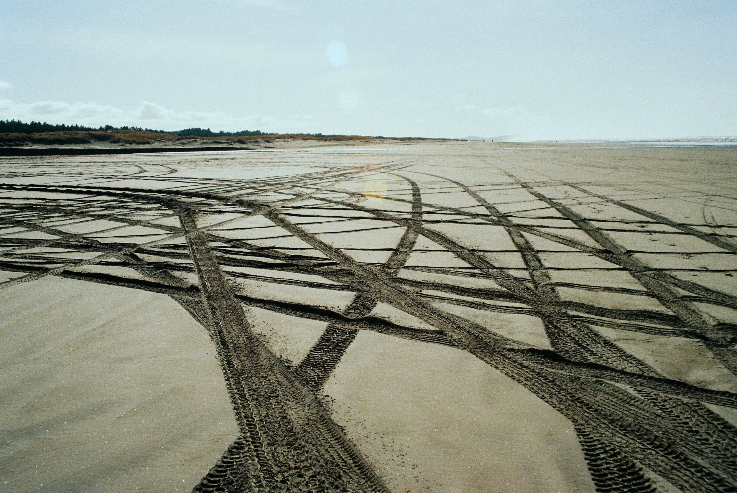 flat sandy landscape with criss-crossing tire tracks