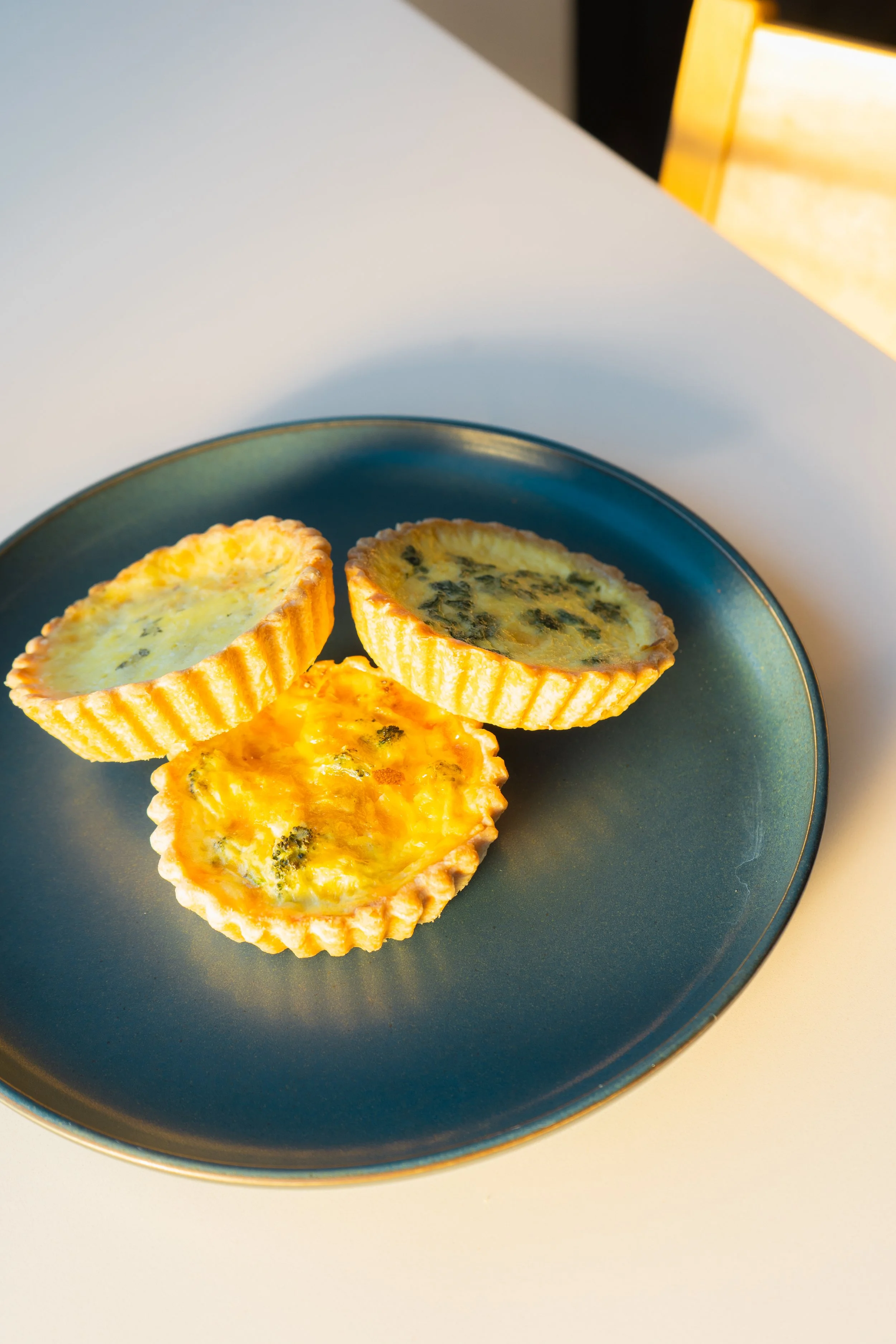 fresh, flaky mini quiches pilled on a blue plate