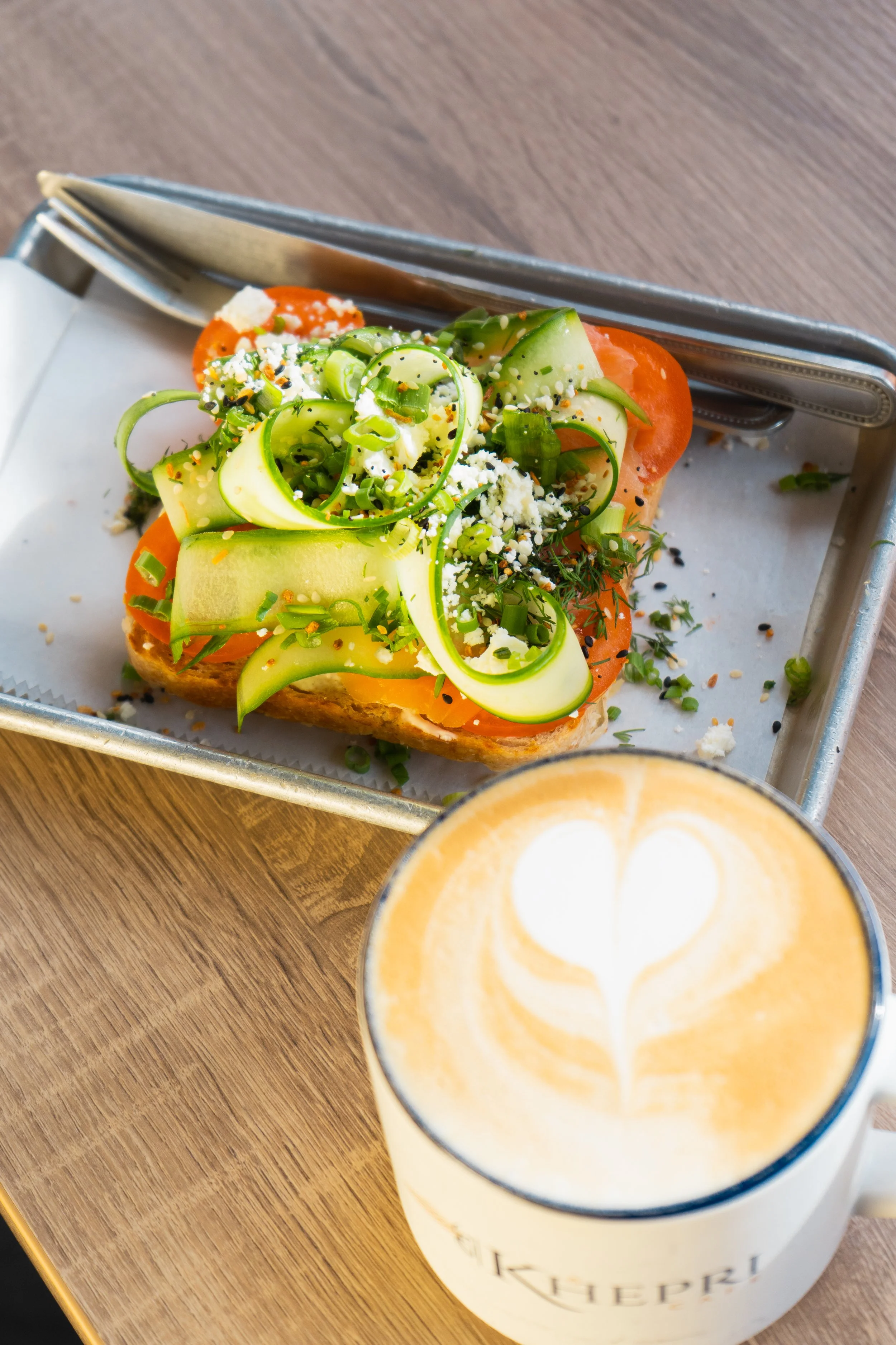 incredibly delicious lox toast pilled high with shaved cucumber, tomatoes, herbs and seasonings.