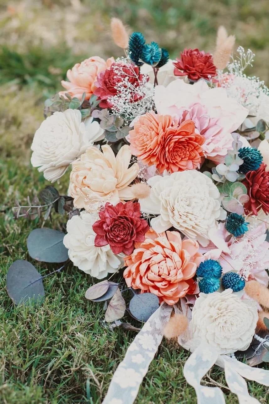 Colorful bouquet of artificial flowers on grass