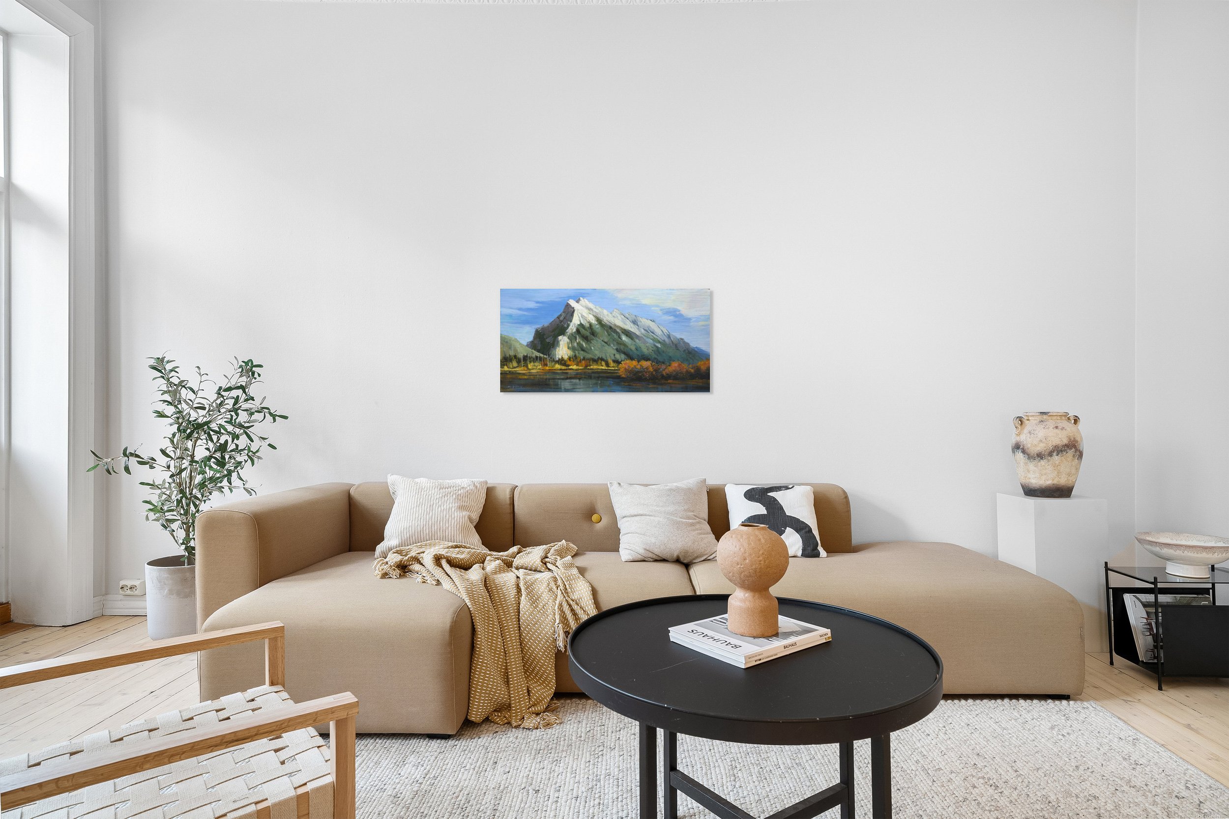 Mount Rundle Peak by Martin Pryce, unsigned print above a beige sectional sofa in a bright living room