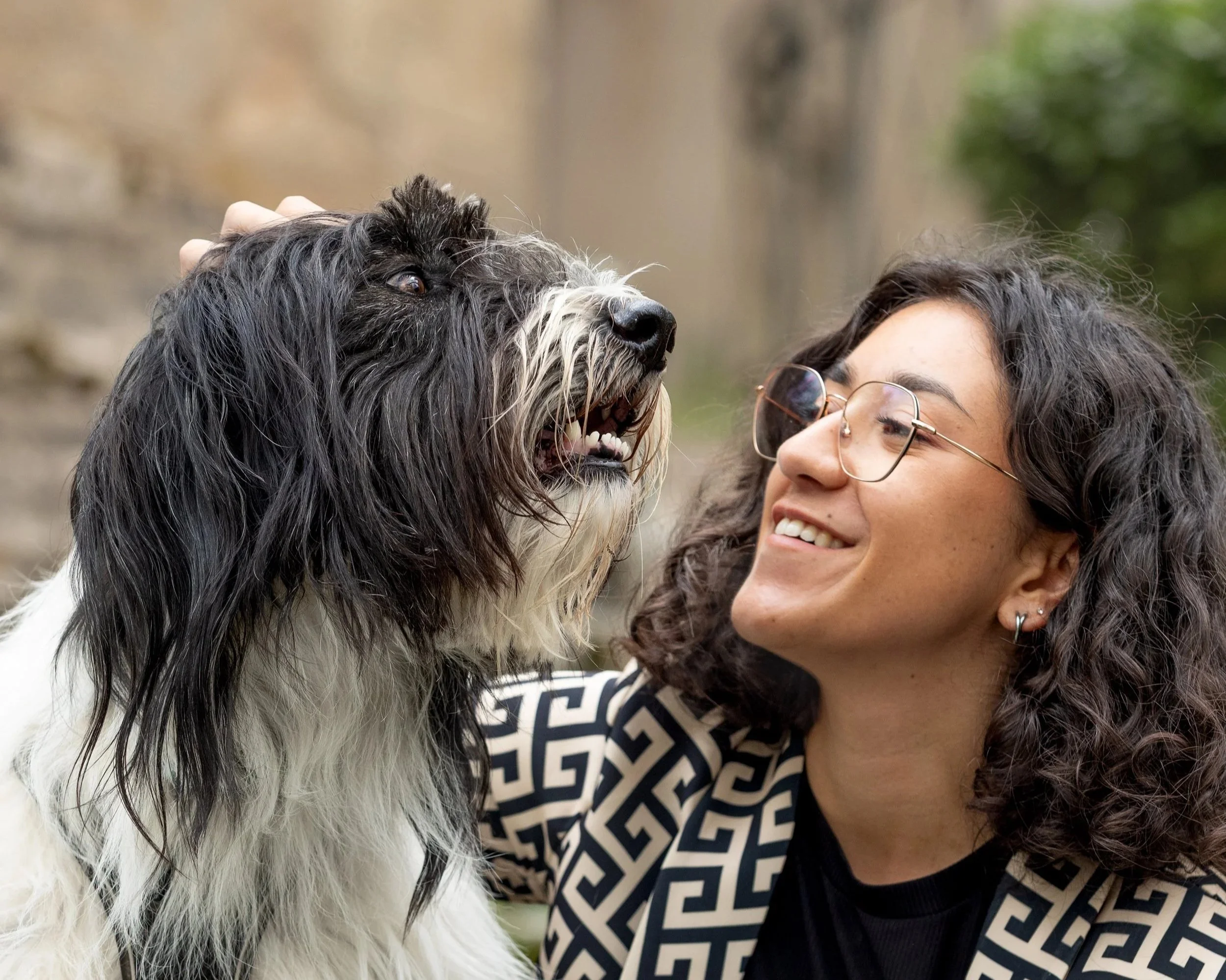 Une femme souriante regarde un chien noir et blanc qu'elle caresse sur la tête. conférence clicker training, En Route Vers l'Osmose, 19/02/2026, espace zola brive la gaillarde