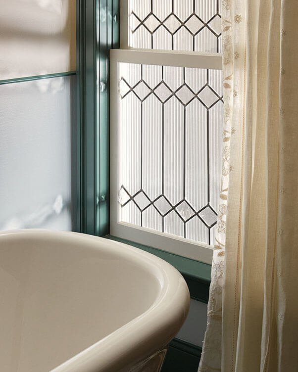 Leaded glass window and freestanding tub detail in a Philadelphia primary bathroom by Vestige Home