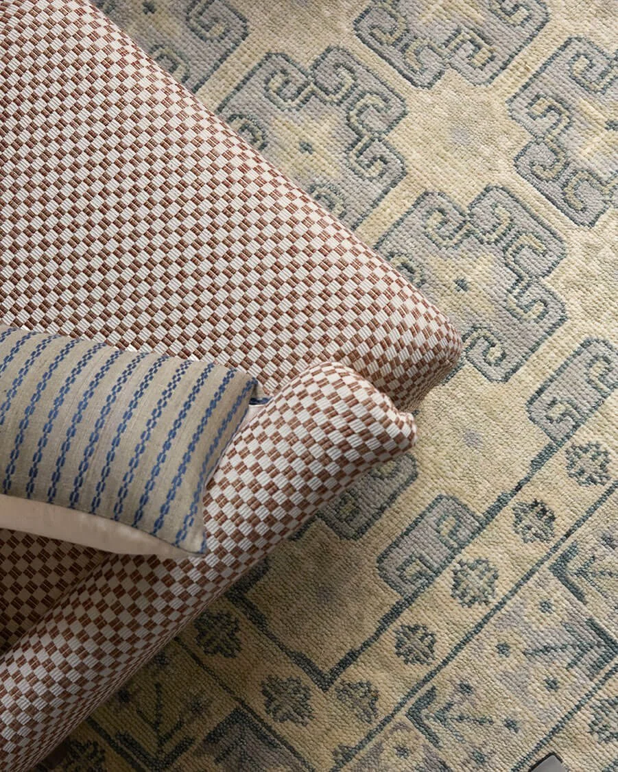 Detail of checkerboard-patterned armchairs and a patterned wool rug in a Philadelphia living room by Vestige Home